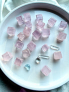 Mini rose quartz cubes with natural blush pink color and subtle clarity variation, polished sacred geometry crystals