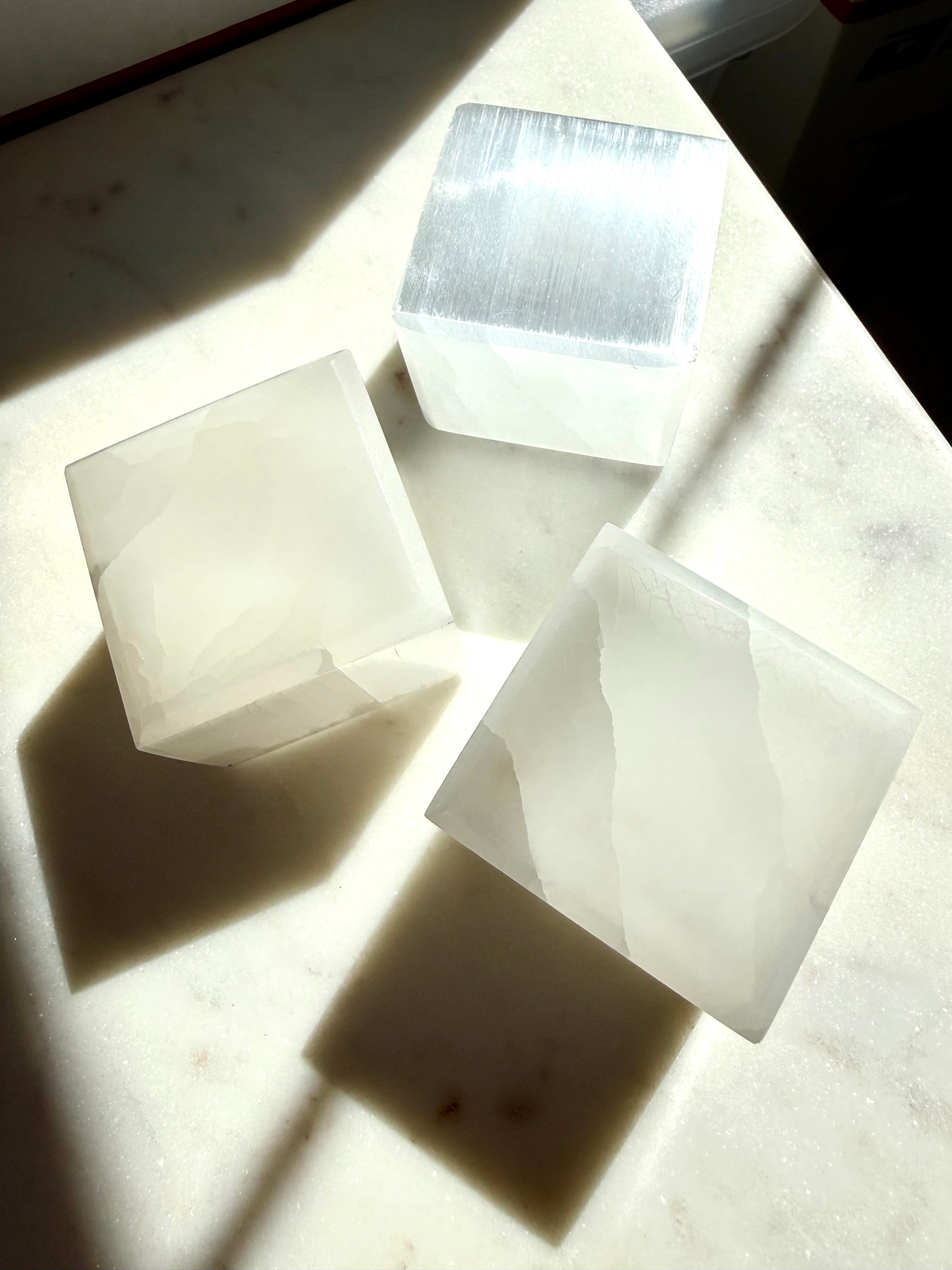 White Selenite crystal cubes arranged in sunlight for energy cleansing, charging and meditation