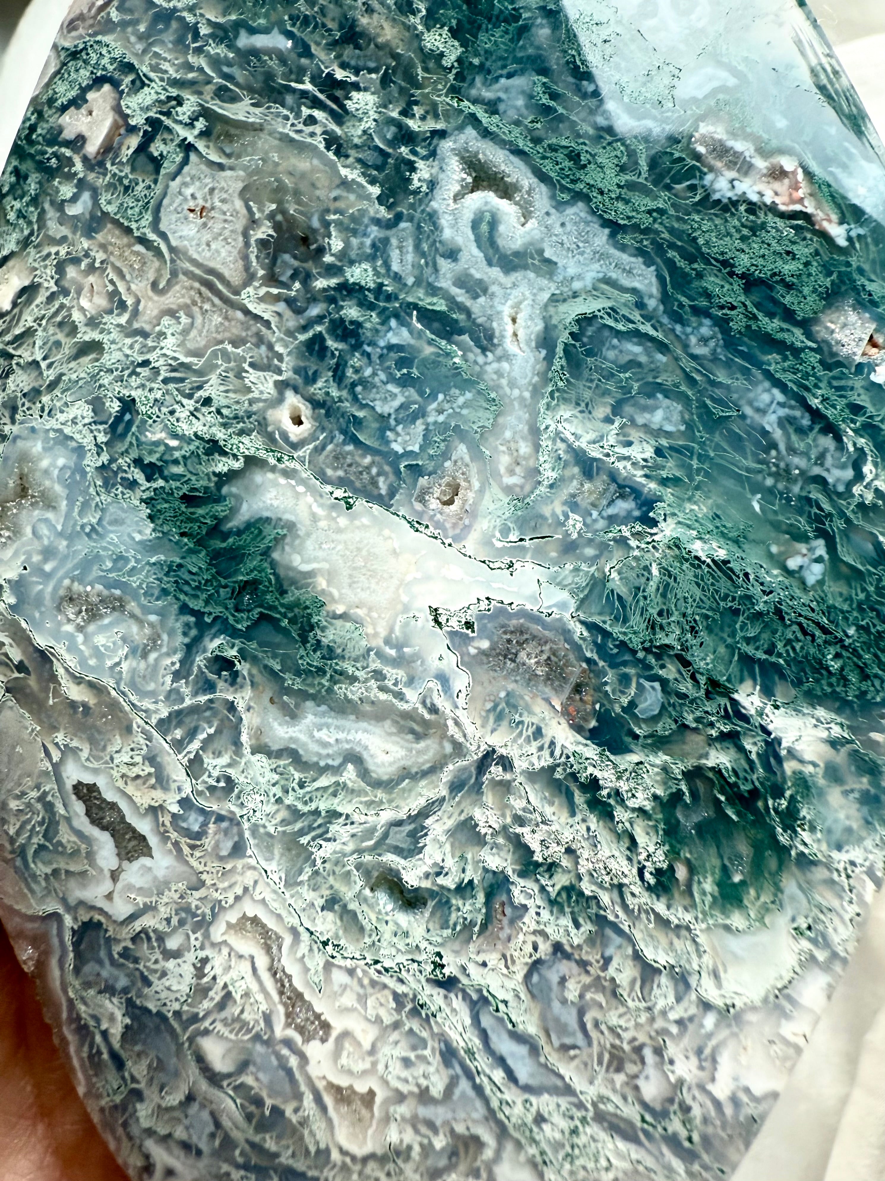 Macro detail of large moss agate crystal flame with blue-green chlorite inclusions and lacy agate formations