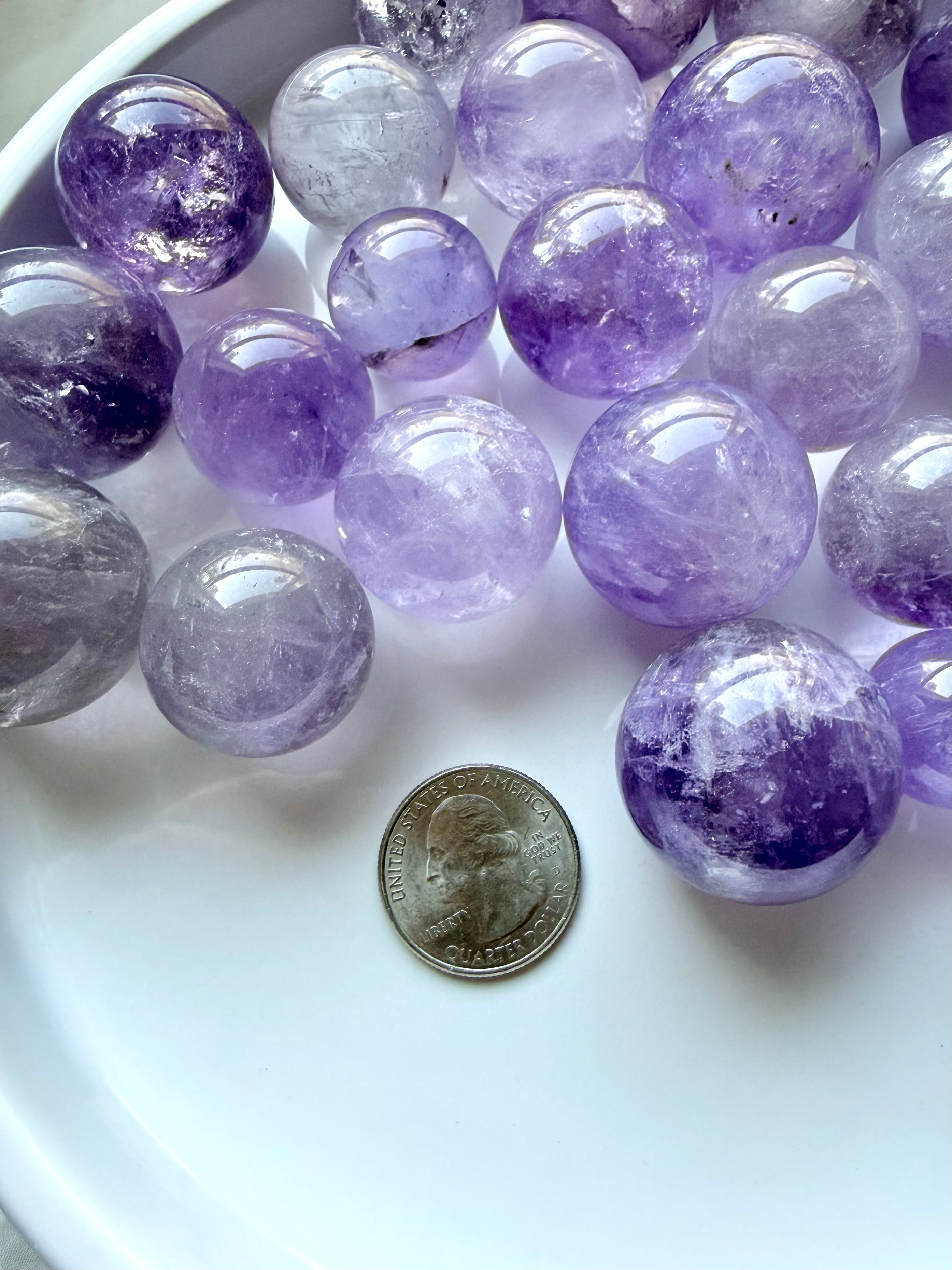 small amethyst crystal spheres with quarter for size reference mini smoky amethyst crystal balls in lavender and gray tones