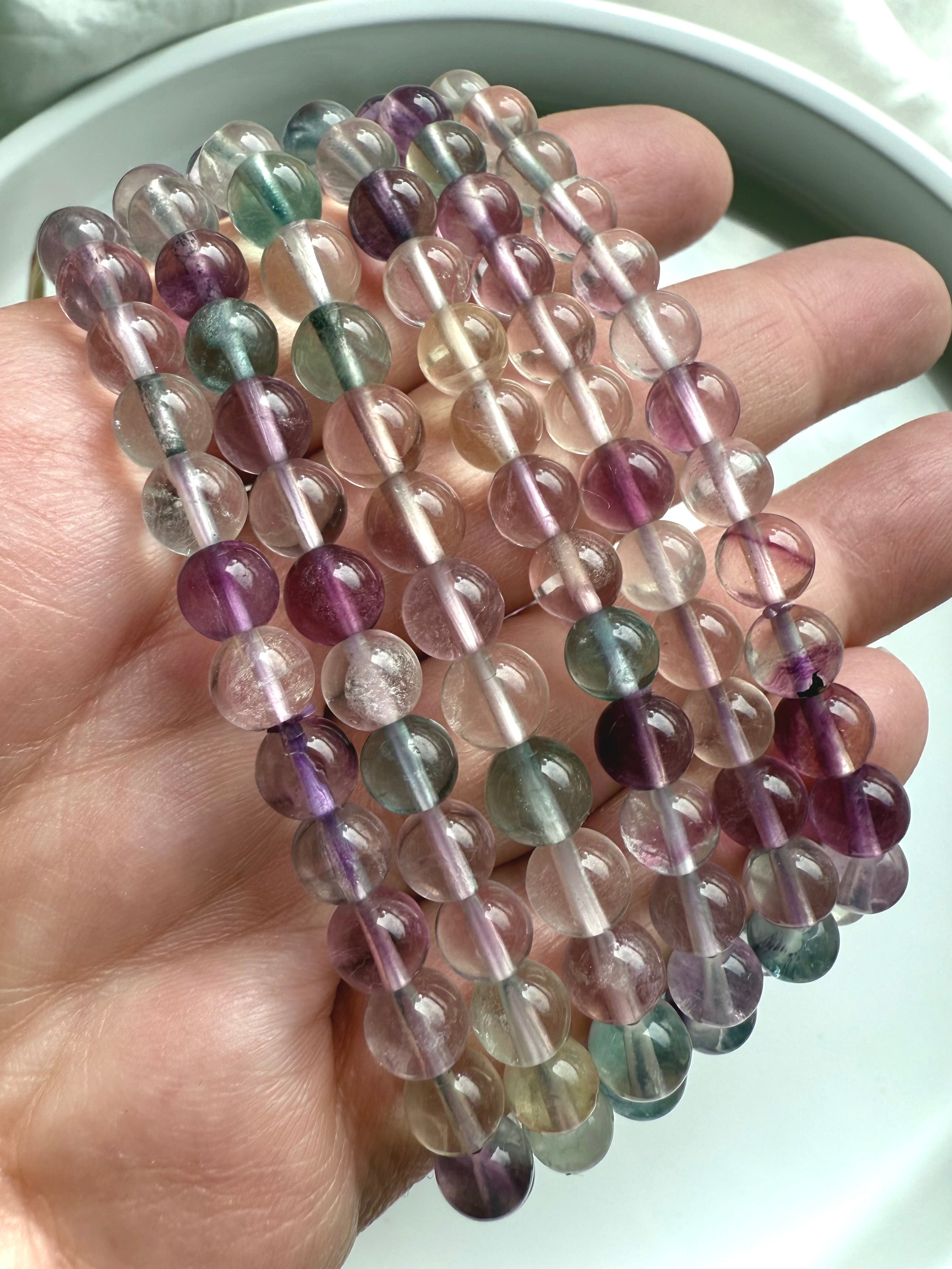 Close-up of high clarity fluorite crystal beads showing natural banding and rainbow color variation