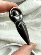 Silver Sheen Obsidian goddess carving held in hand showing polished shape and shimmering silver sheen