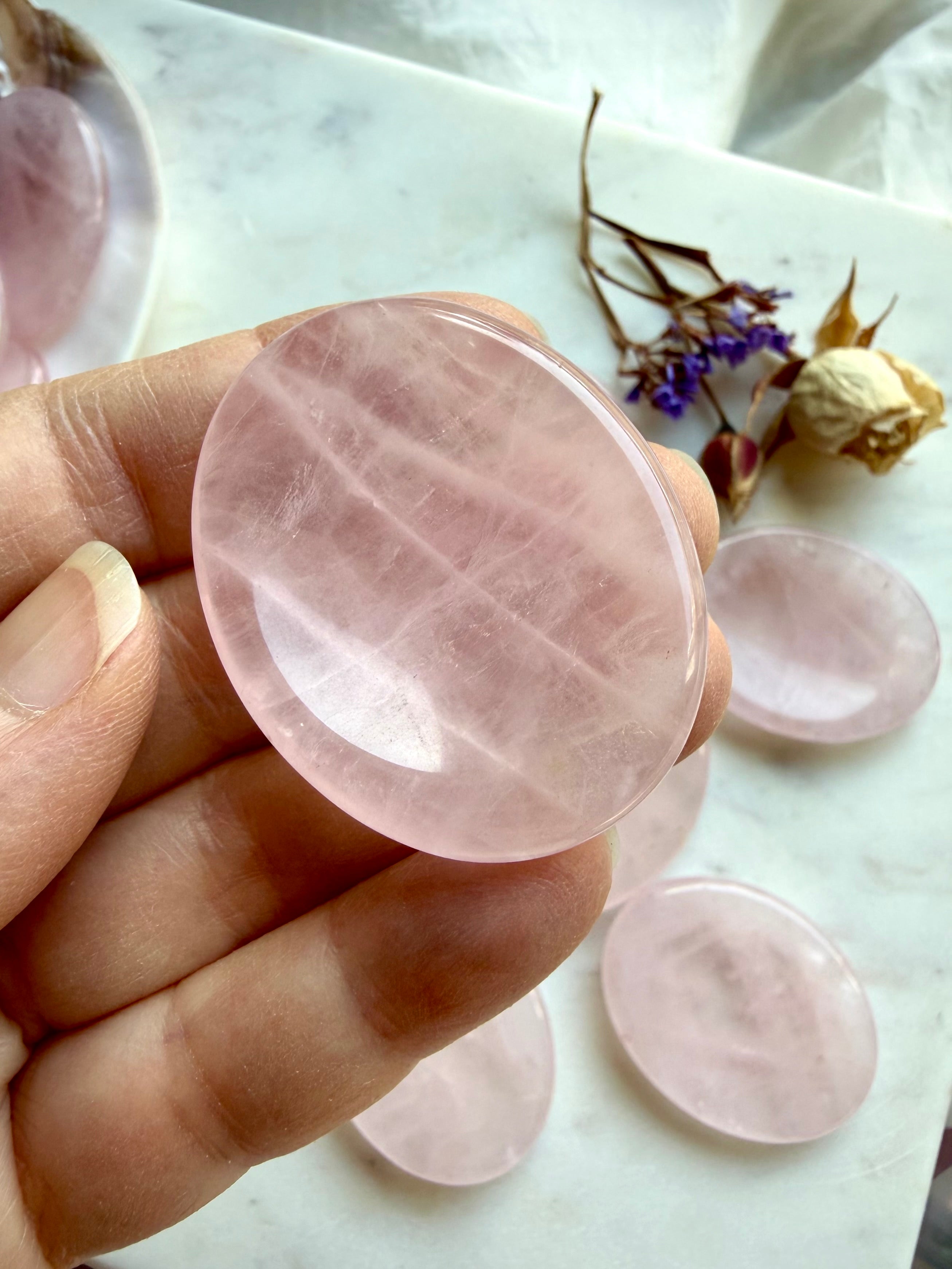 rose quartz worry stone held in hand showing smooth oval shape for soothing anxiety relief