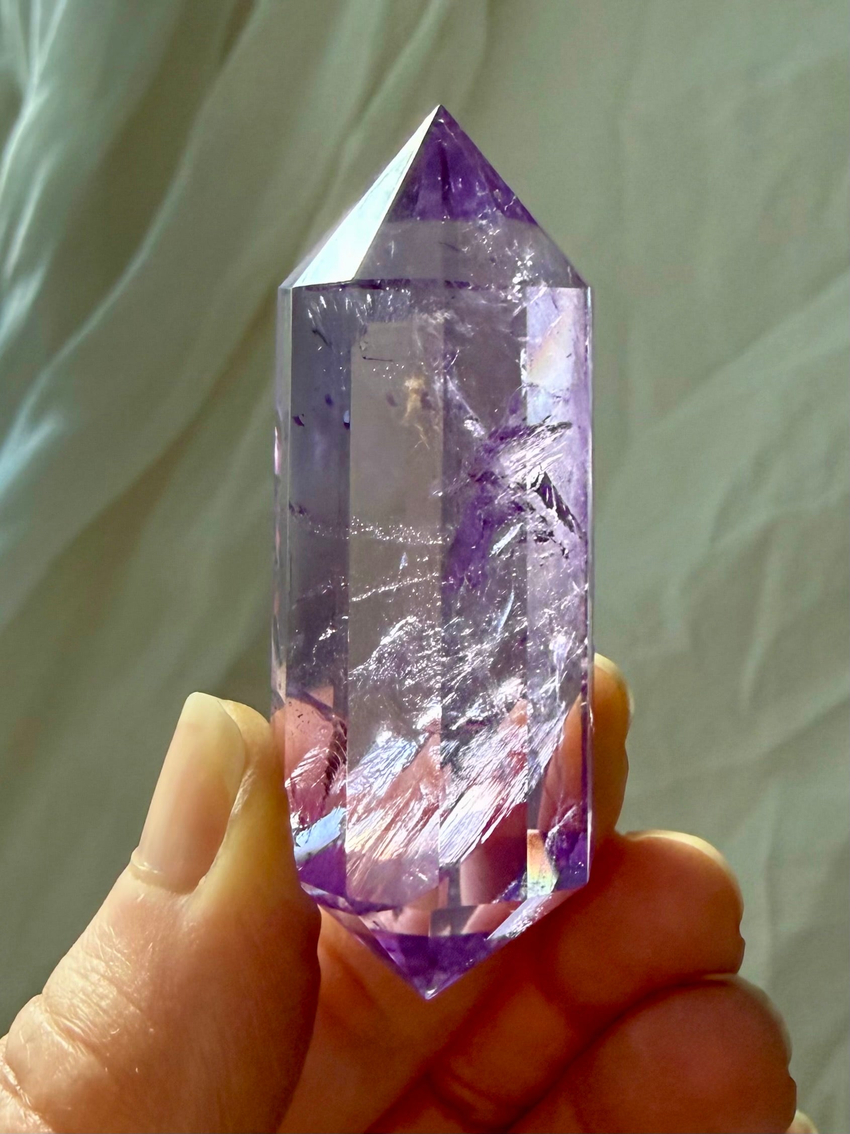 Faceted Amethyst Vogel crystal wand from Brazil with rainbow inclusions and luminous color