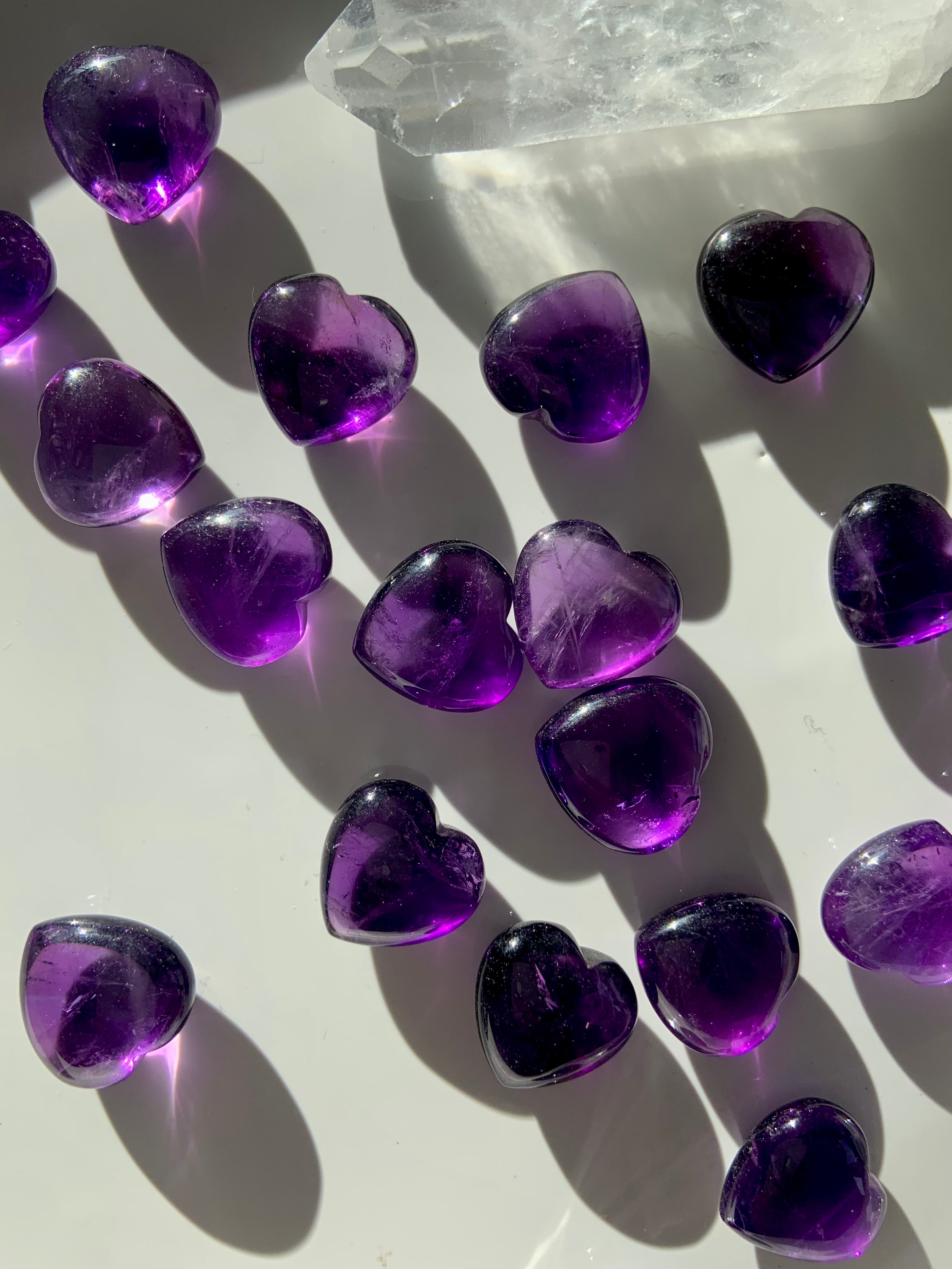 Gemmy Amethyst hearts with a quartz point on white — mini purple crystals for spiritual healing