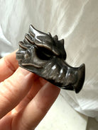 angled view of silver sheen obsidian dragon carving showing sculpted details and high-gloss finish, grounding crystal for shadow integration