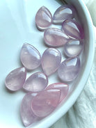 Luminous Rose Quartz teardrops with soft pink-lavender tones, high translucence and smooth rounded shapes