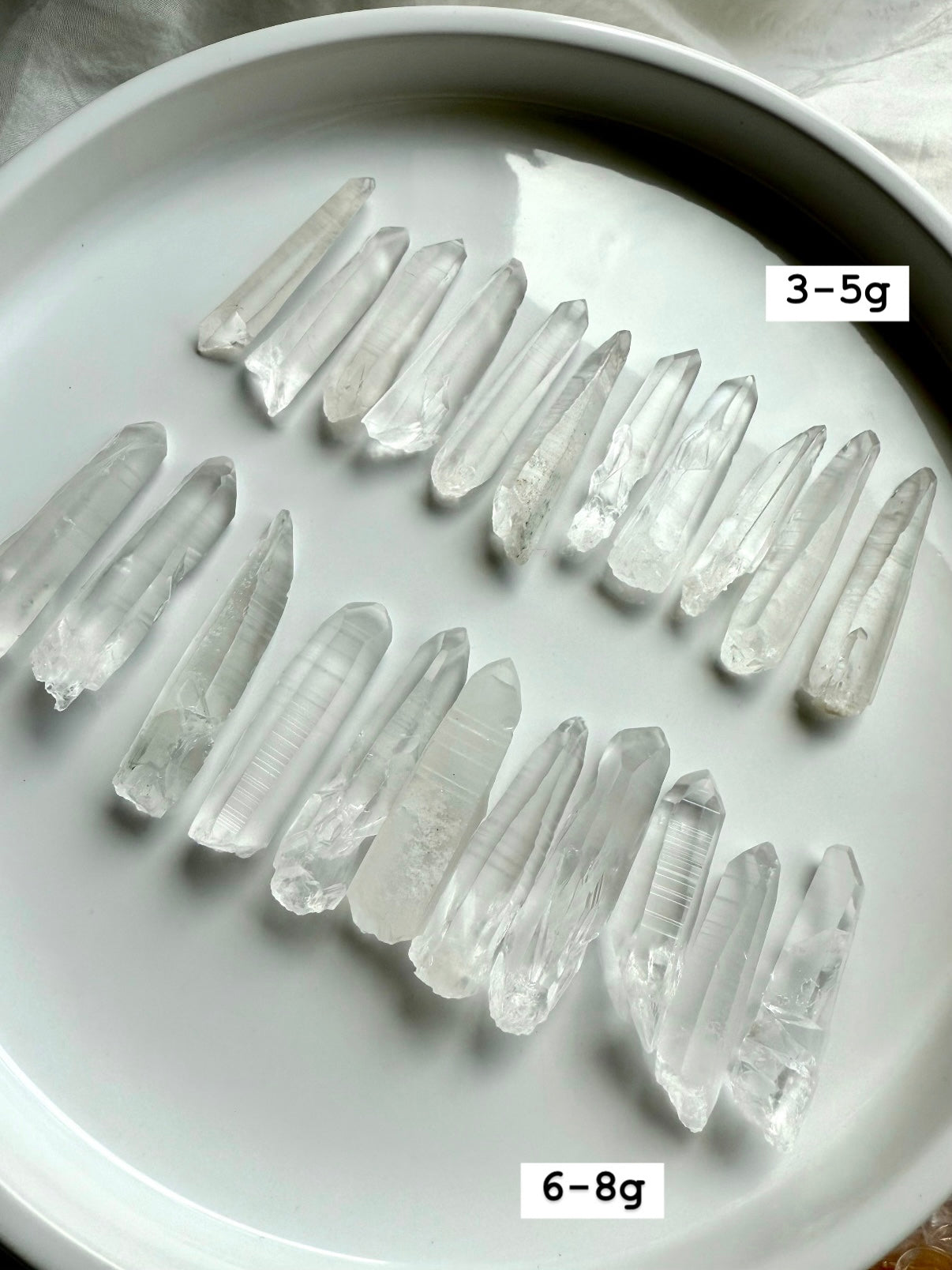 Lemurian Quartz Points displayed on a white plate with sizes labeled — authentic Brazilian crystals for energy healing & soul-level activation.