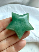 Green Aventurine star carving held in hand showing soft green color, polished finish, and gently beveled shape