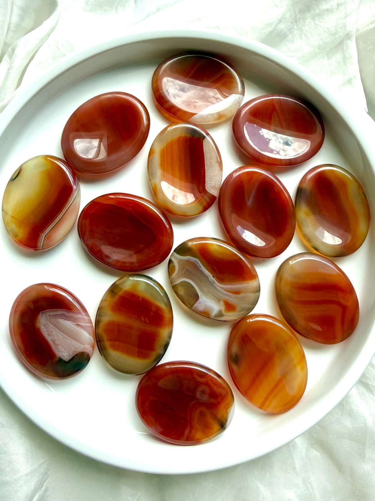 Collection of Carnelian Agate worry stones with red, orange, amber and golden translucent color variations
