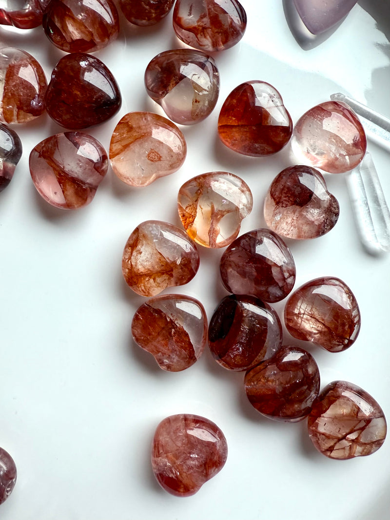 Gemmy Fire Quartz Crystal Hearts shown on a white plate, photographed in natural light