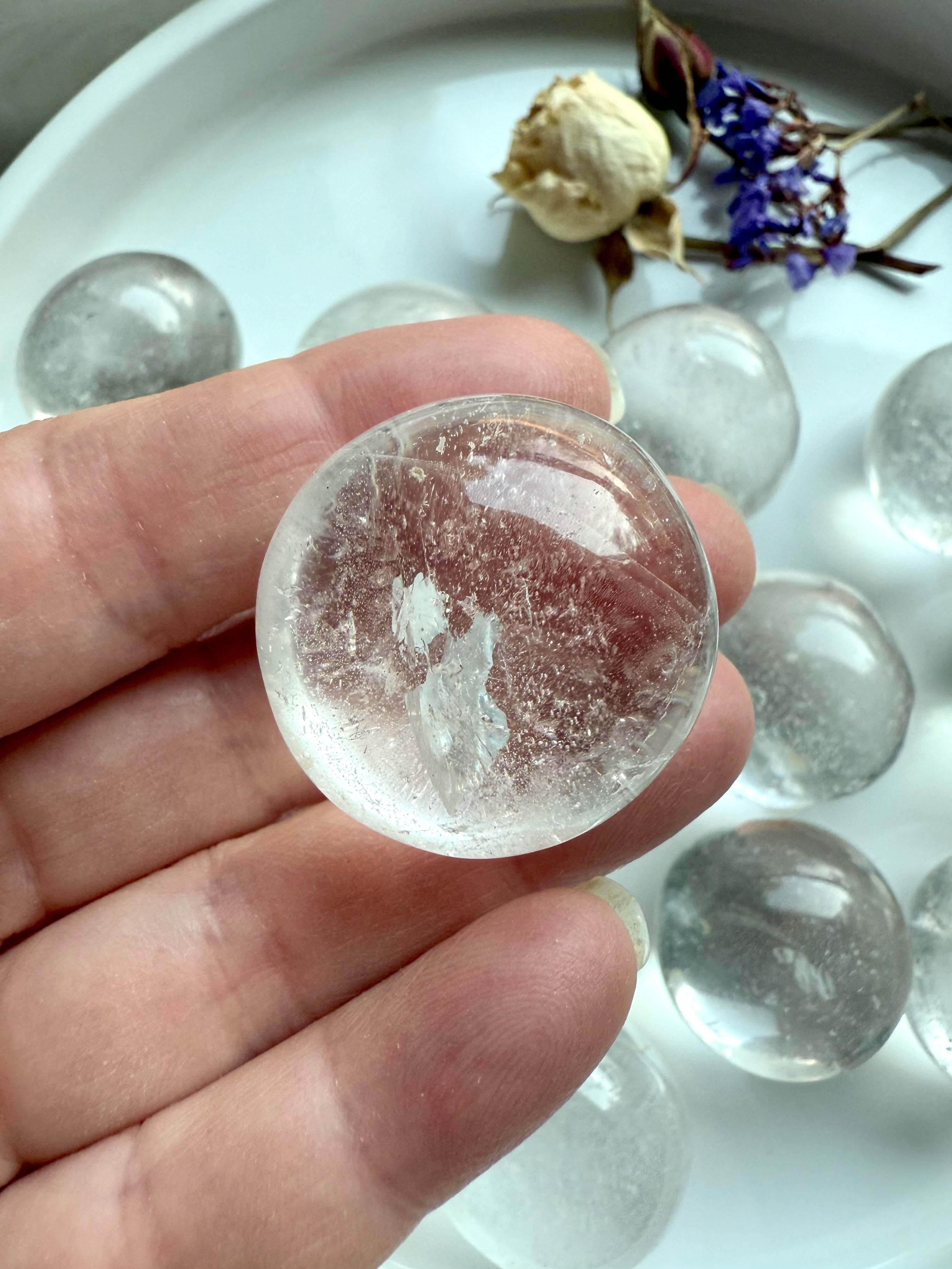 Macro close-up of a Clear Quartz tumbled stone highlighting internal patterns and silvery flash