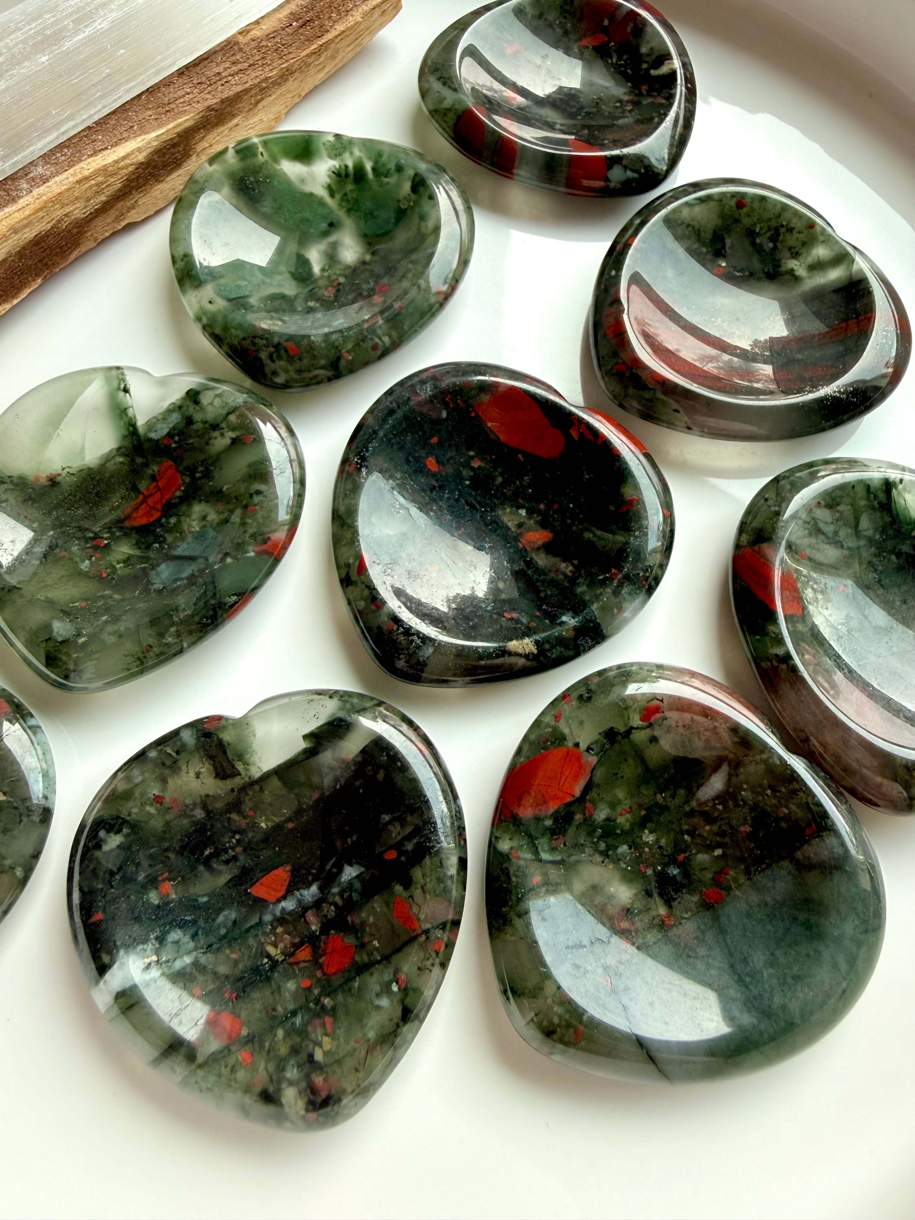 bloodstone heart worry stones with deep green base and red inclusions on marble, grounding crystal for strength stress relief and root chakra
