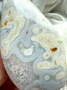 Close-up of white Moss Agate flame with orbicular formations and glossy polish