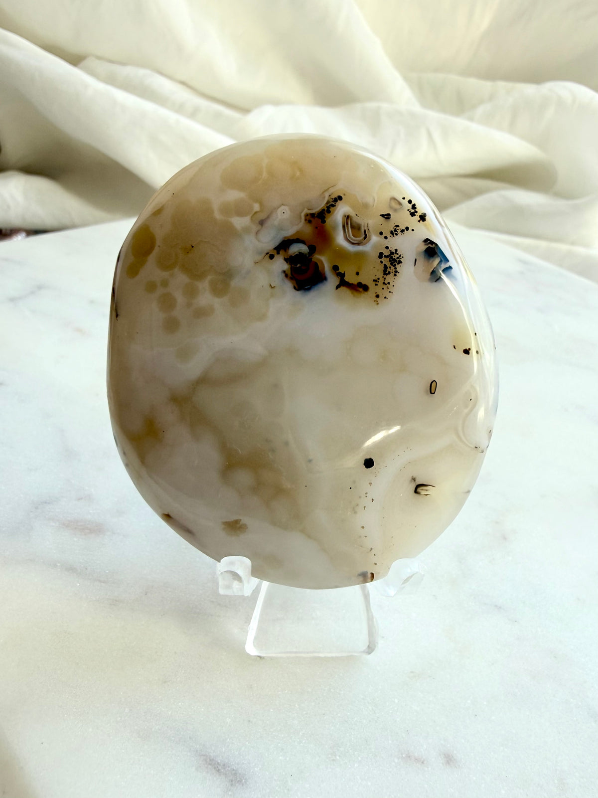 Dendritic Agate freeform shown on included stand, highlighting its naturally irregular shape, smooth polish and earthy inclusions