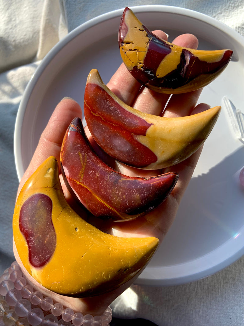 Big, colorful Mookaite Jasper Crescent Moon Carvings shown on my hand for scale. Choose your favorite from the dropdown menu.