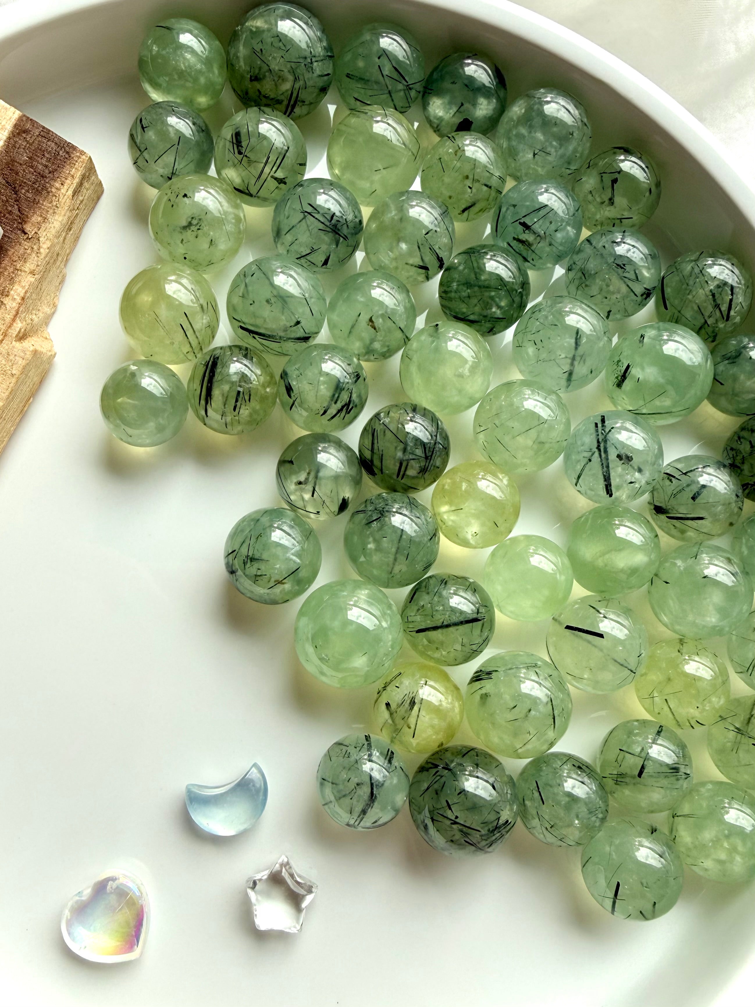 prehnite mini spheres with epidote inclusions showing translucent green tones and natural variation on white tray