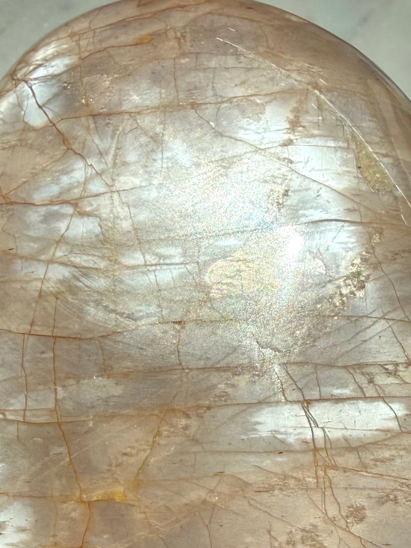 Close-up of Peach Moonstone freeform showing luminous silver flash, natural crack lines and warm peach orange coloring