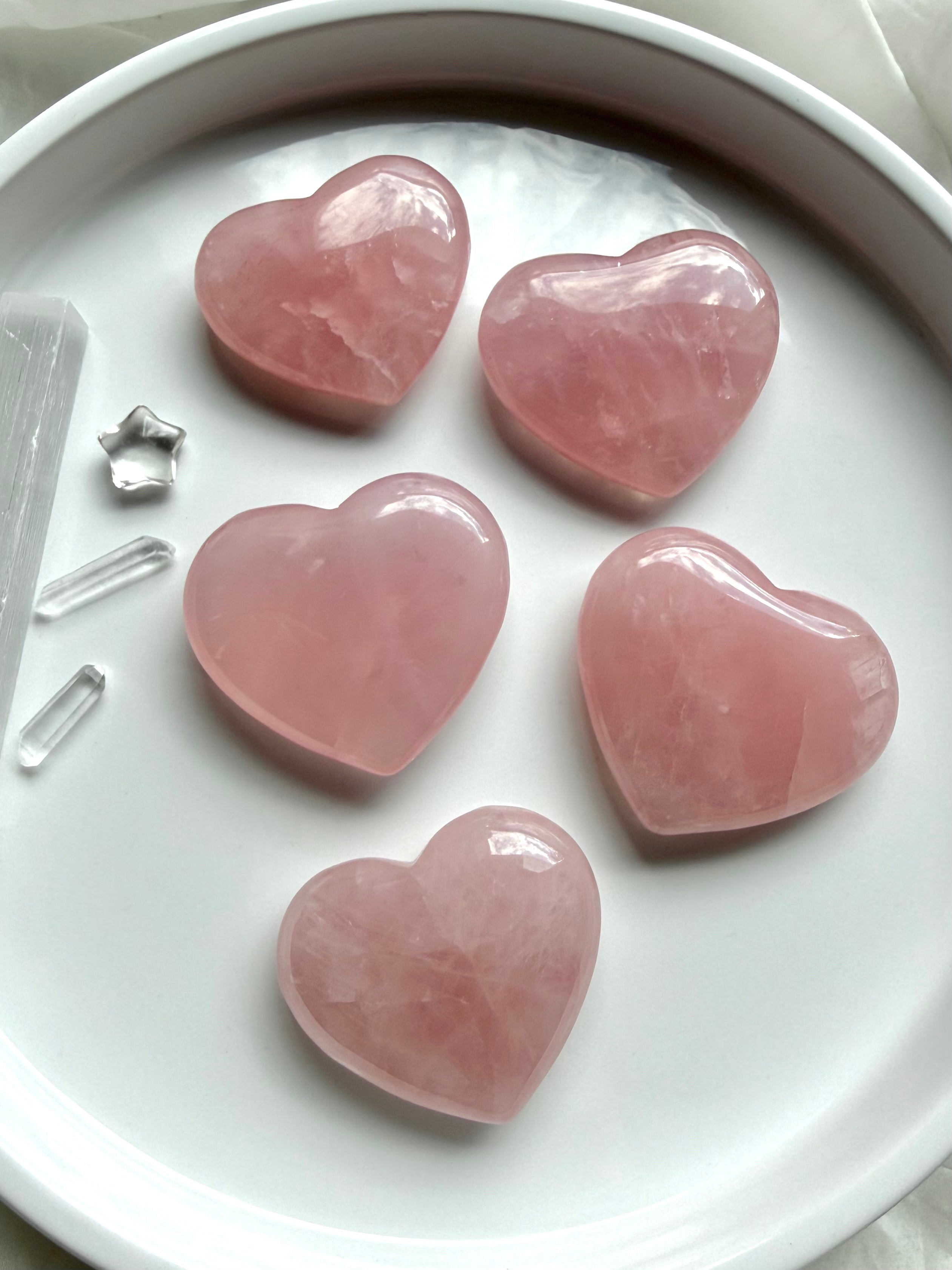 Rose Quartz hearts with soft translucent pink color, palm-sized crystal carvings for love, emotional healing and Heart Chakra energy