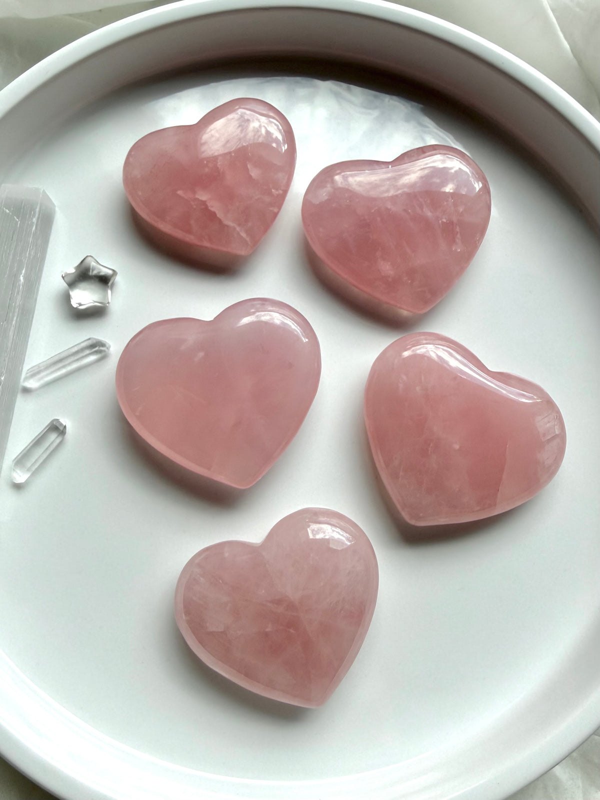 Rose Quartz hearts with soft translucent pink color, palm-sized crystal carvings for love, emotional healing and Heart Chakra energy