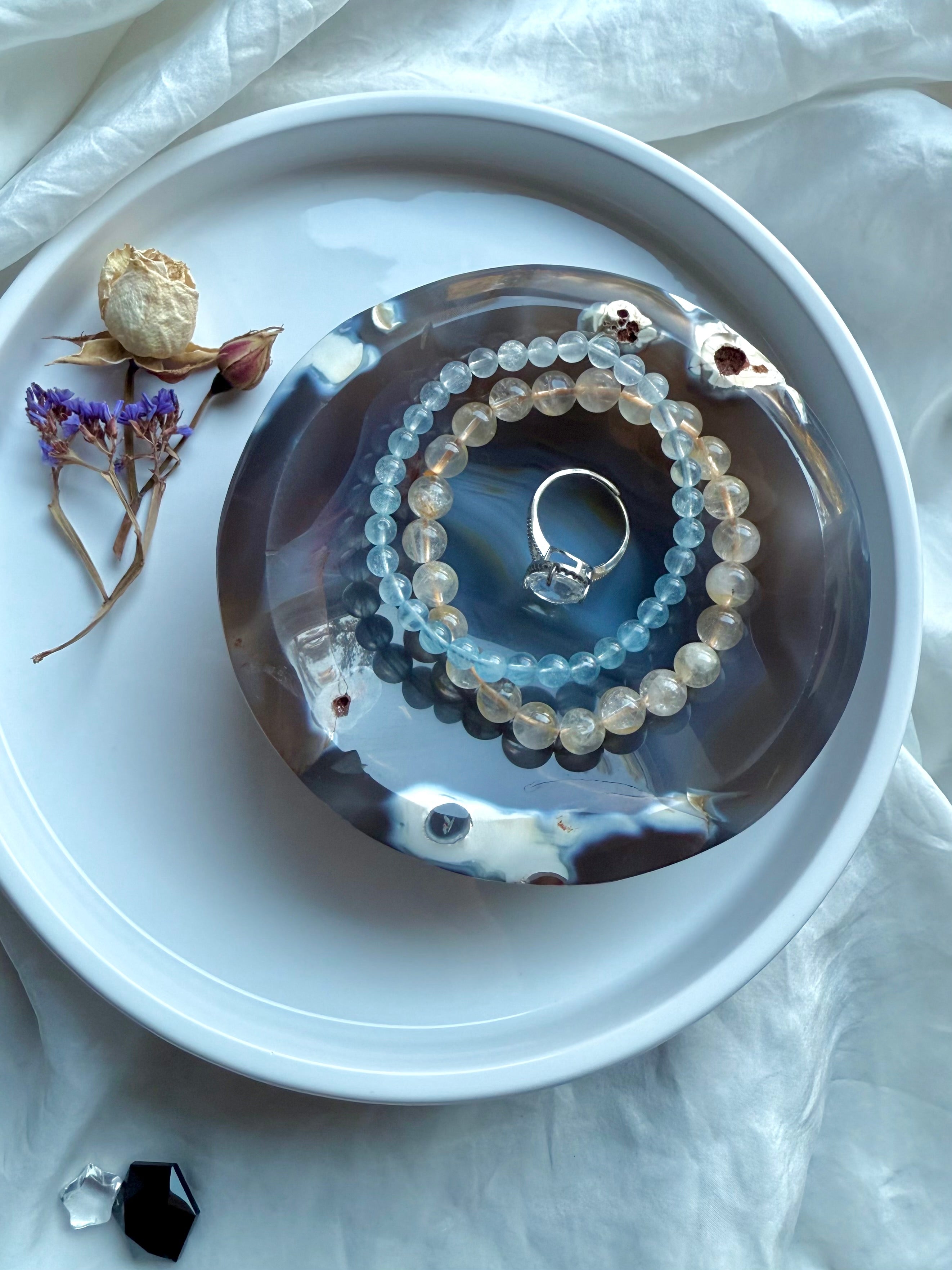Orca Agate offering bowl displayed with gemstone bracelets and ring, styled as an altar dish for sacred jewelry