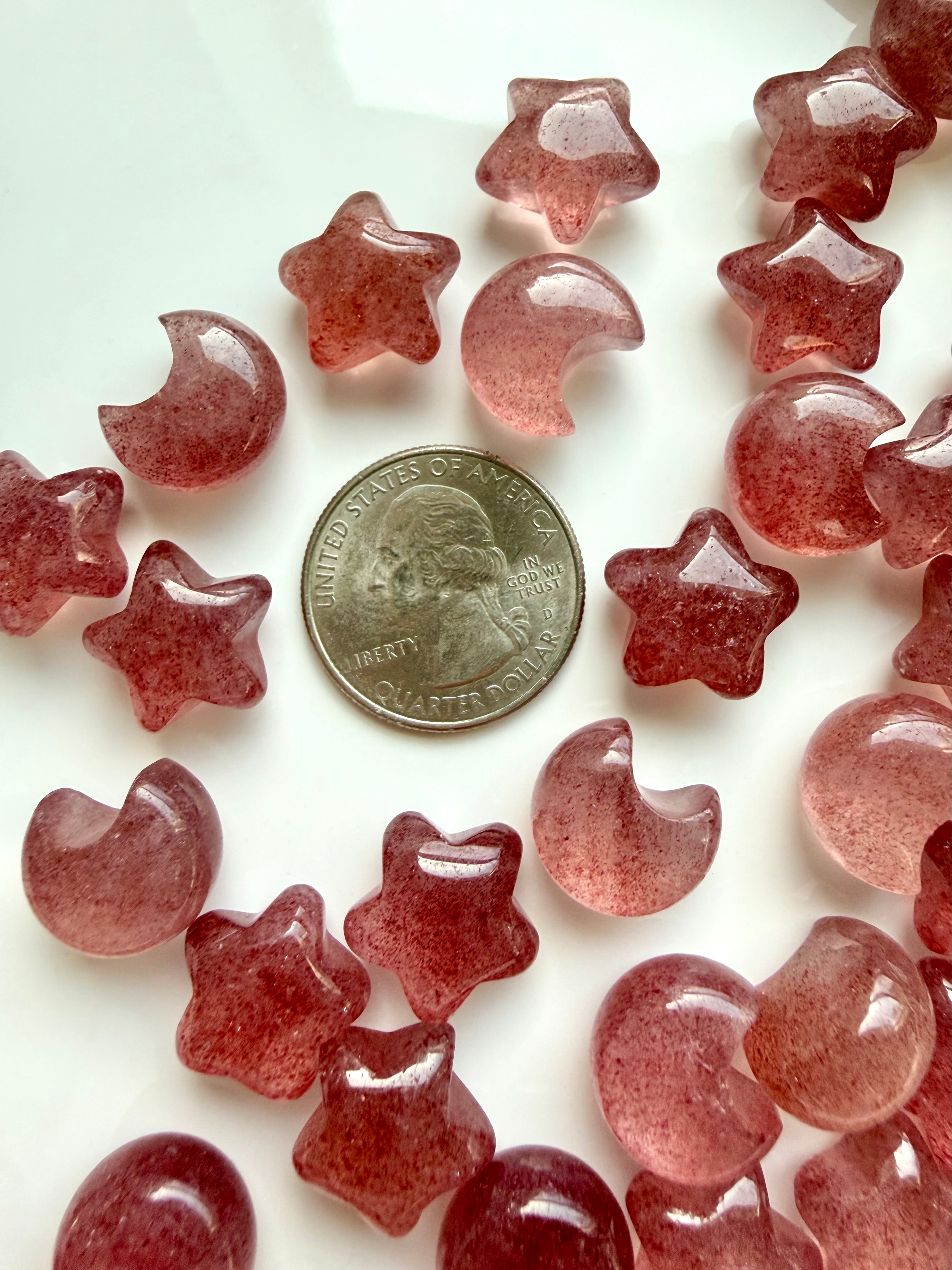 Strawberry Quartz mini moons and stars shown with a US quarter for scale, glossy polished crystals in pink and red tones