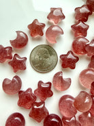 Strawberry Quartz mini moons and stars shown with a US quarter for scale, glossy polished crystals in pink and red tones
