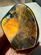Orange Labradorite crystal showing glowing copper flash with pink, purple and blue accents