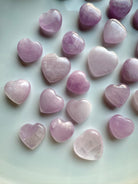Close-up of mini Pink Kunzite hearts on a white background — crystal hearts for peace, compassion & energetic balance.