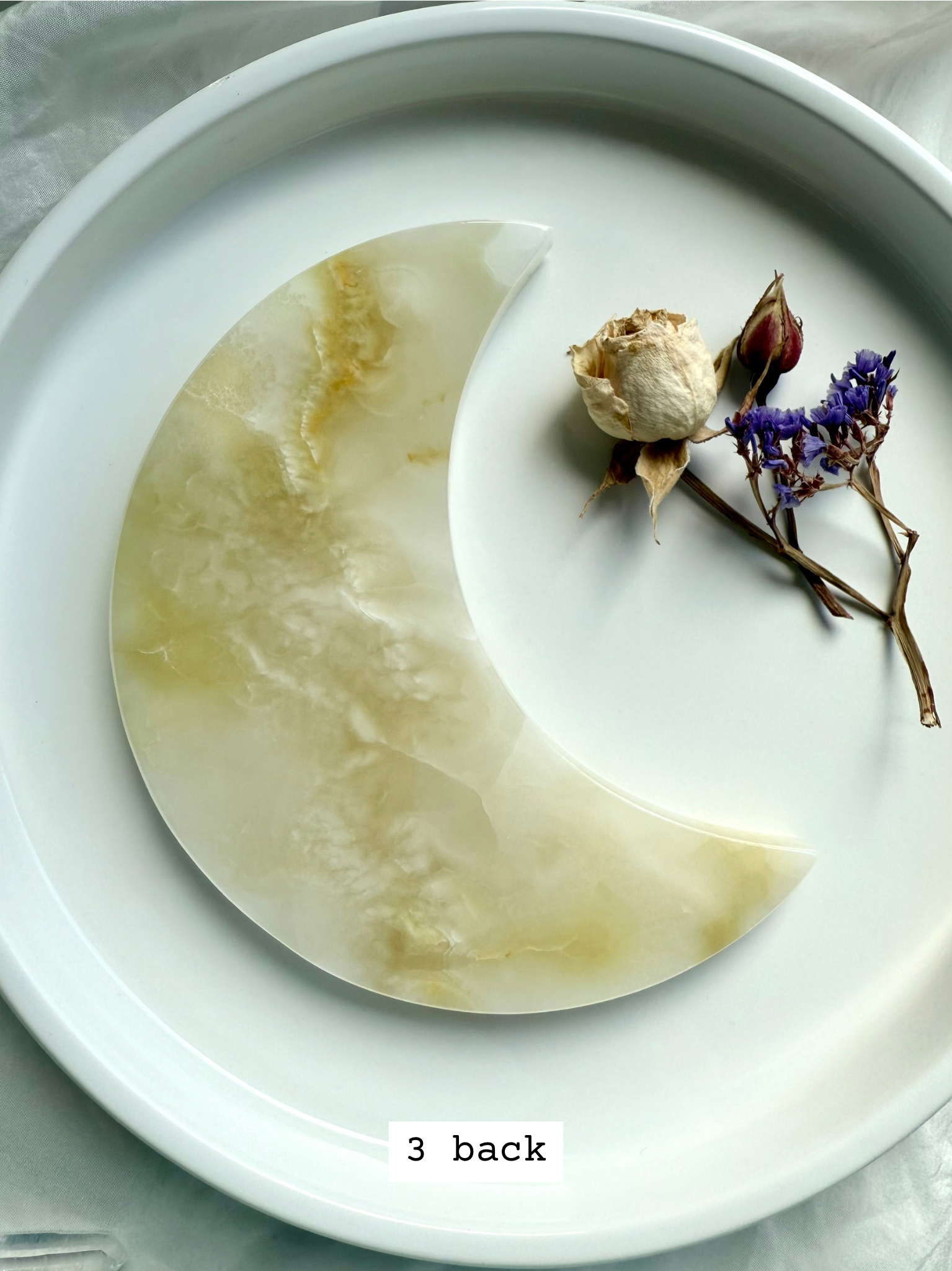 White Onyx Crescent Moon Plate, crystal carving with creamy white and subtle golden patterning, back view.