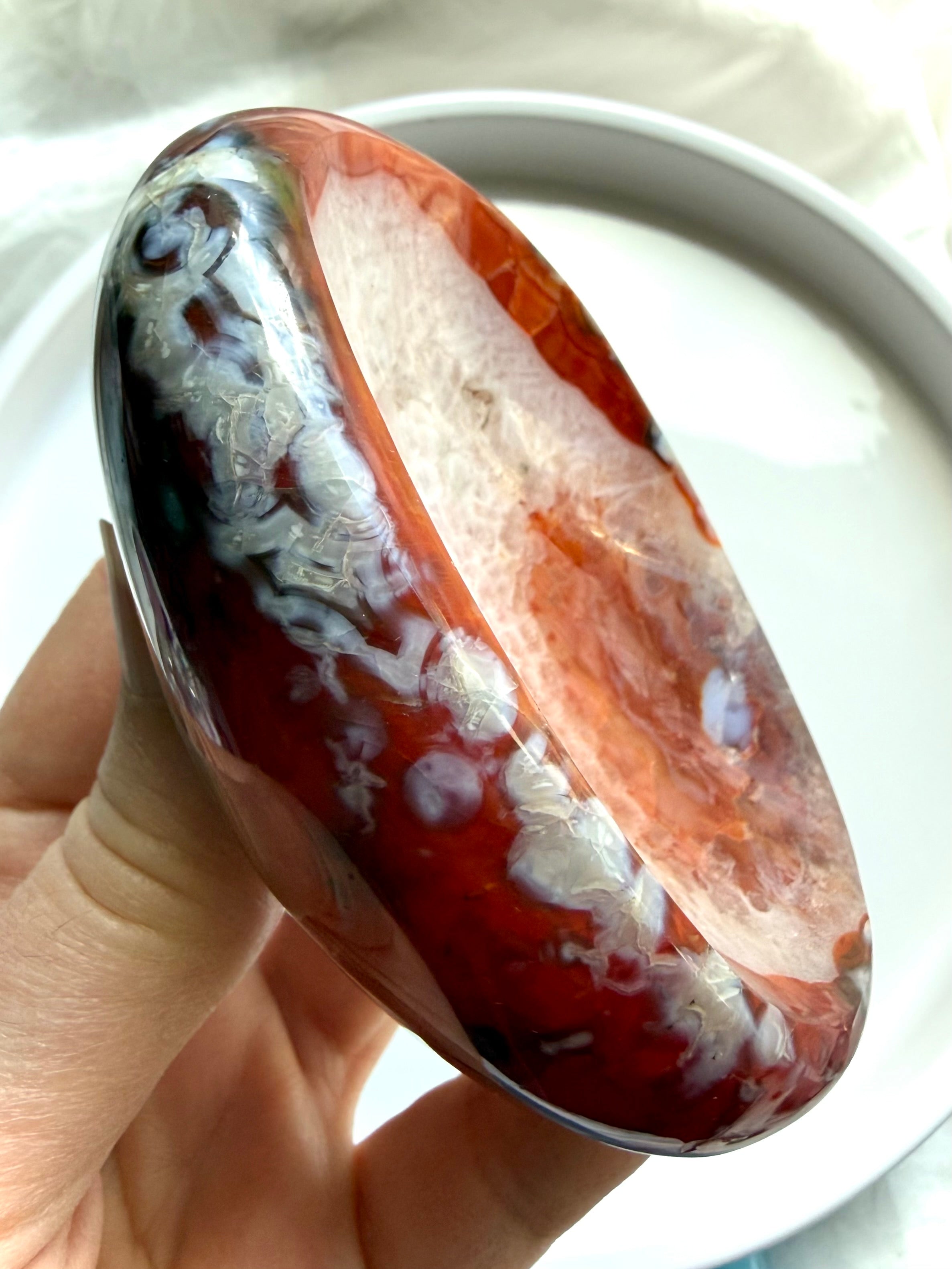 carnelian crystal bowl held in hand with white quartz druzy center and natural agate inclusions