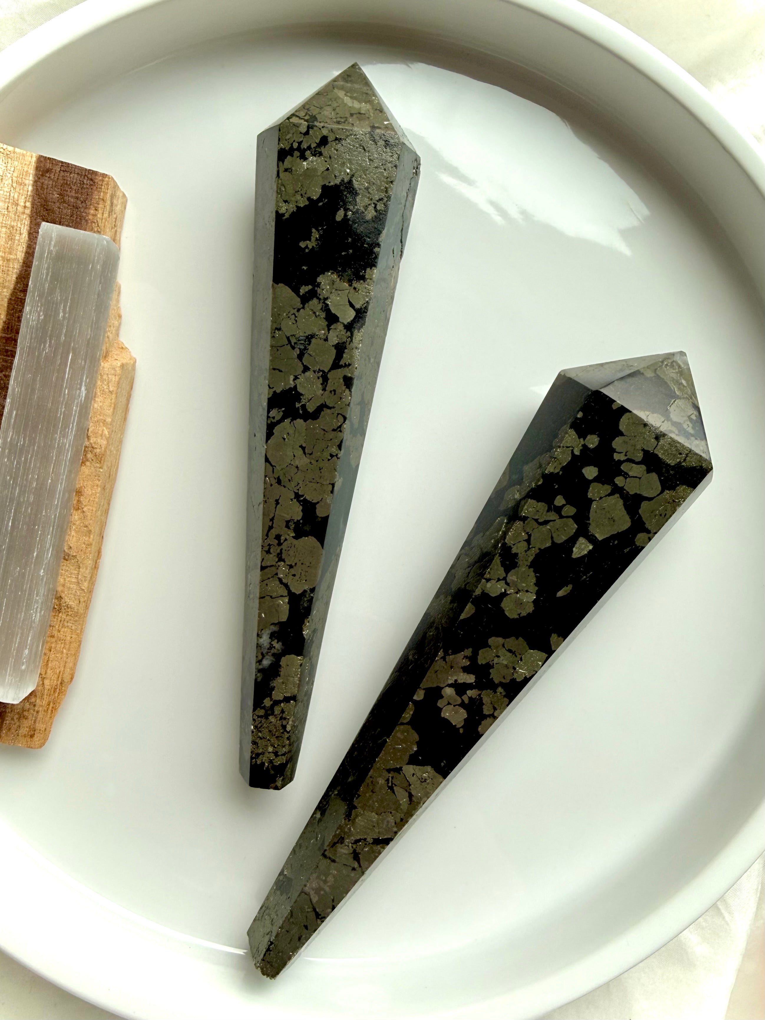 two pyrite wands in black matrix on white tray polished crystal points