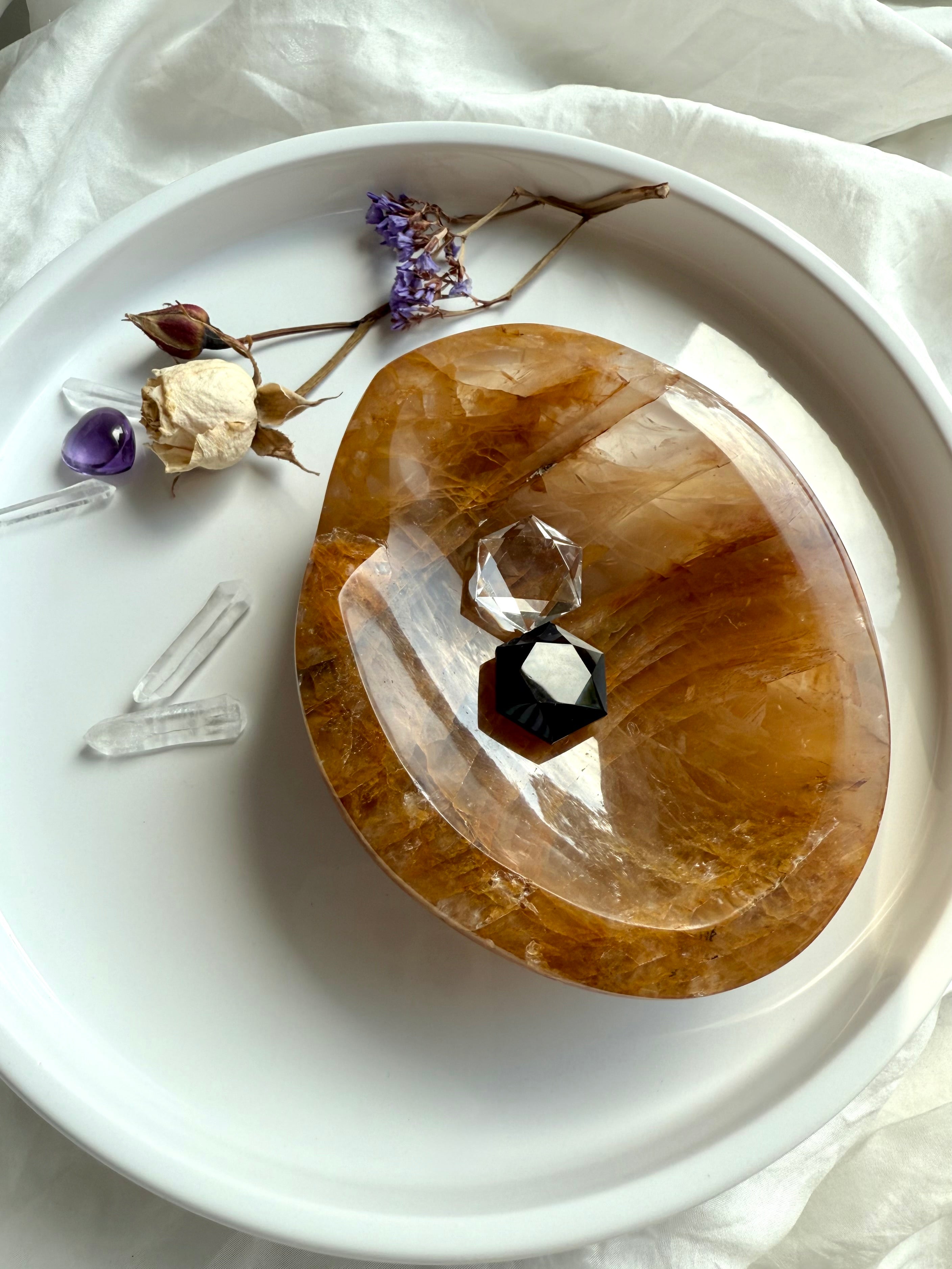 Golden Healer Quartz altar bowl displayed with clear quartz and small crystal hexagons inside