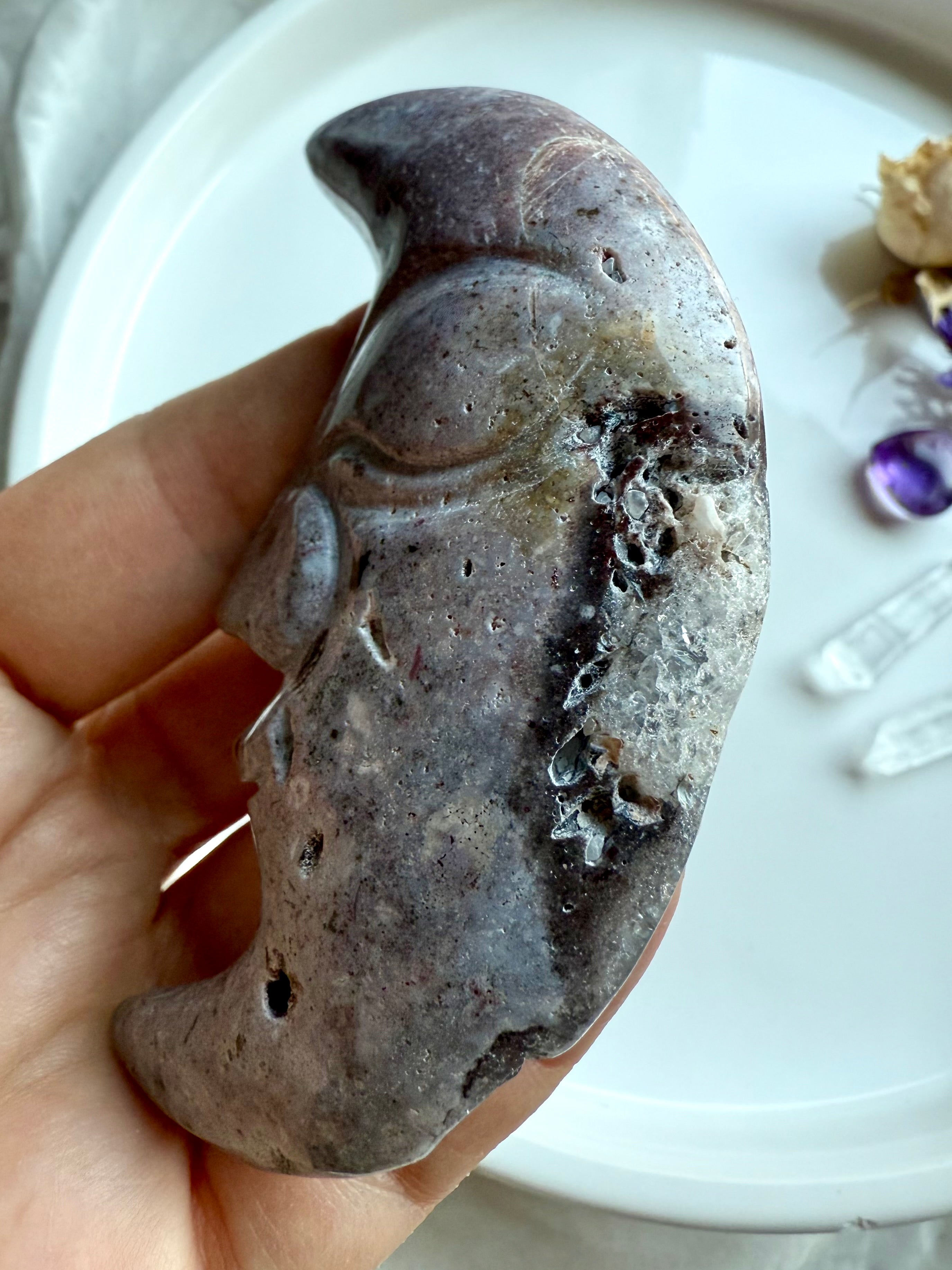 Close-up of Ocean Jasper moon face carving showing sparkling druzy pocket and stone texture.