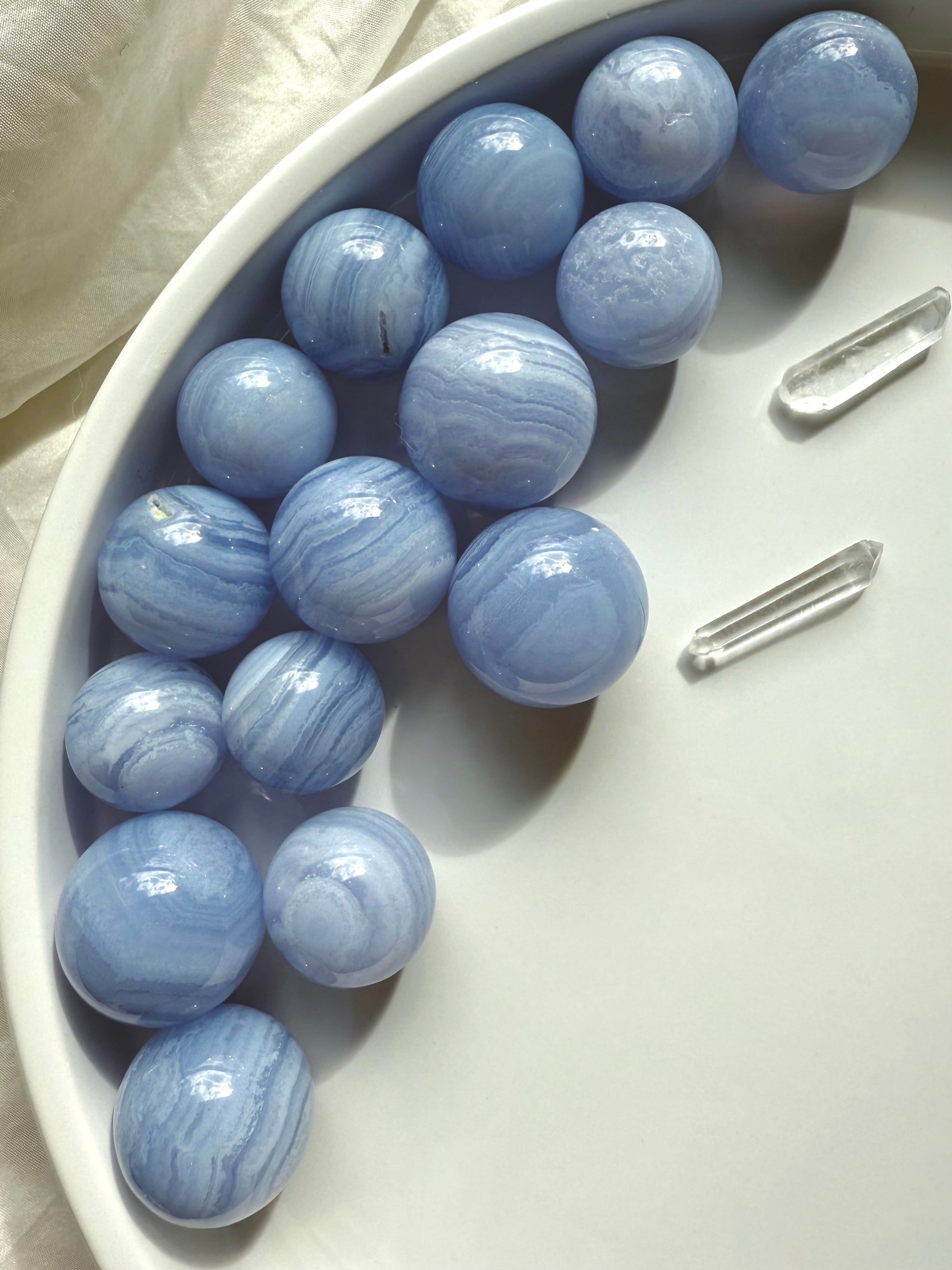 High quality mini Blue Lace Agate Spheres photographed on a white plate in natural light 