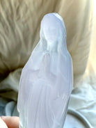 Mother Mary crystal carving held in hand, showing the soft translucent lavender and green coloring of Yttrium Fluorite