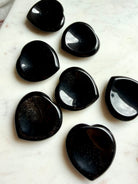 sheen obsidian heart crystals grouped on marble surface for energy clearing and grounding support