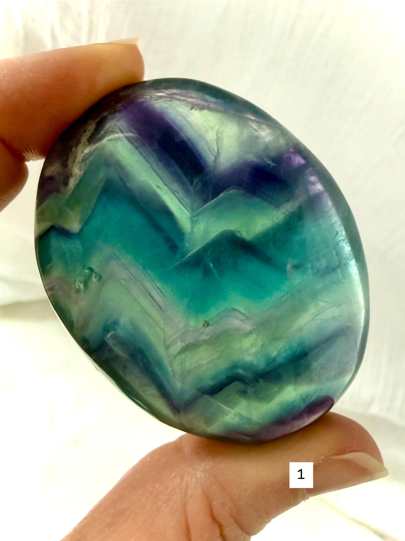 Rainbow Fluorite Palm Stone #1 with teal, aqua and violet banding and translucent color windows