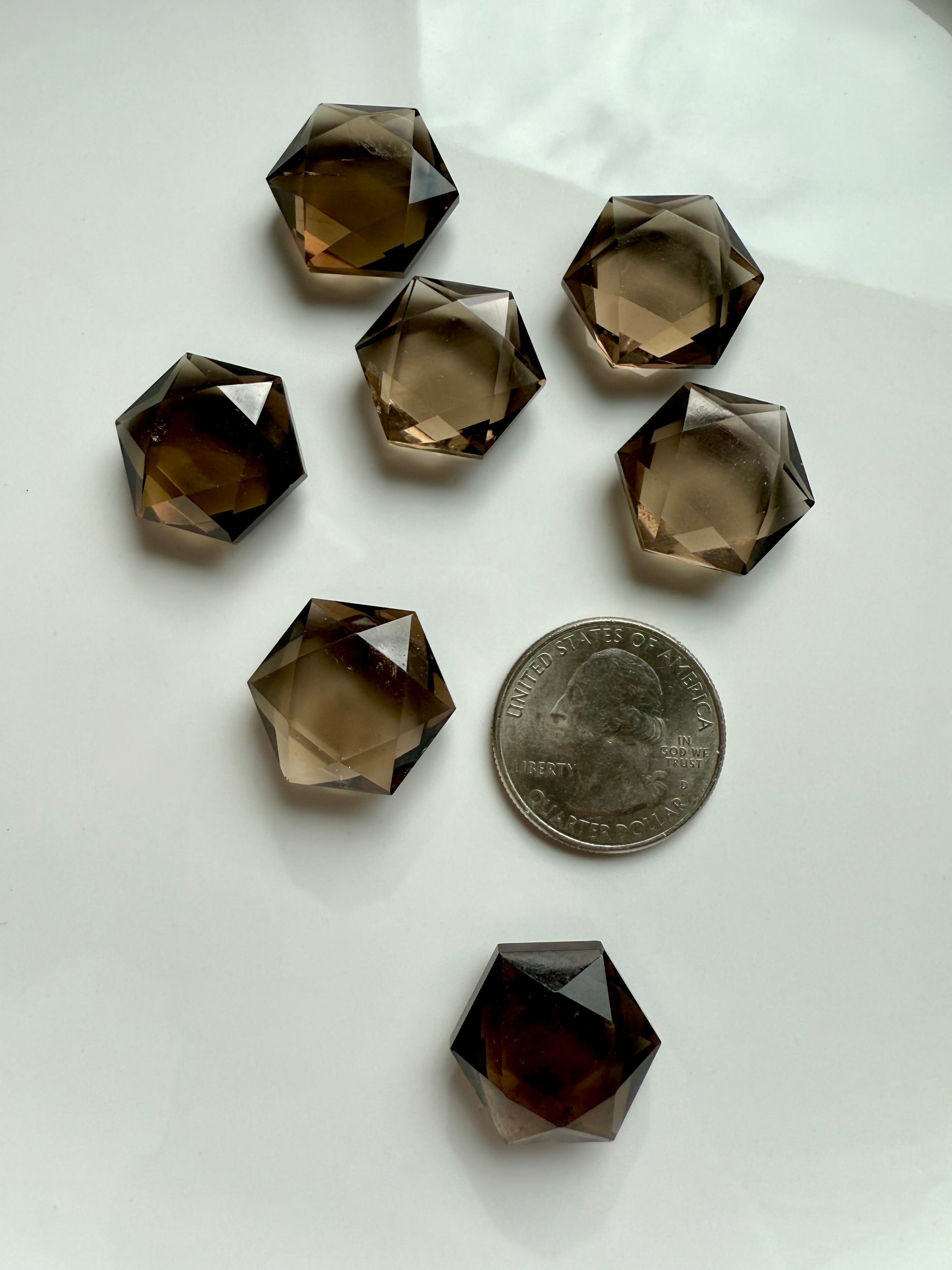 Mini Smoky Quartz hexagon gem with a US quarter for scale, showing clarity, subtle internal patterning, and hand-cut facets