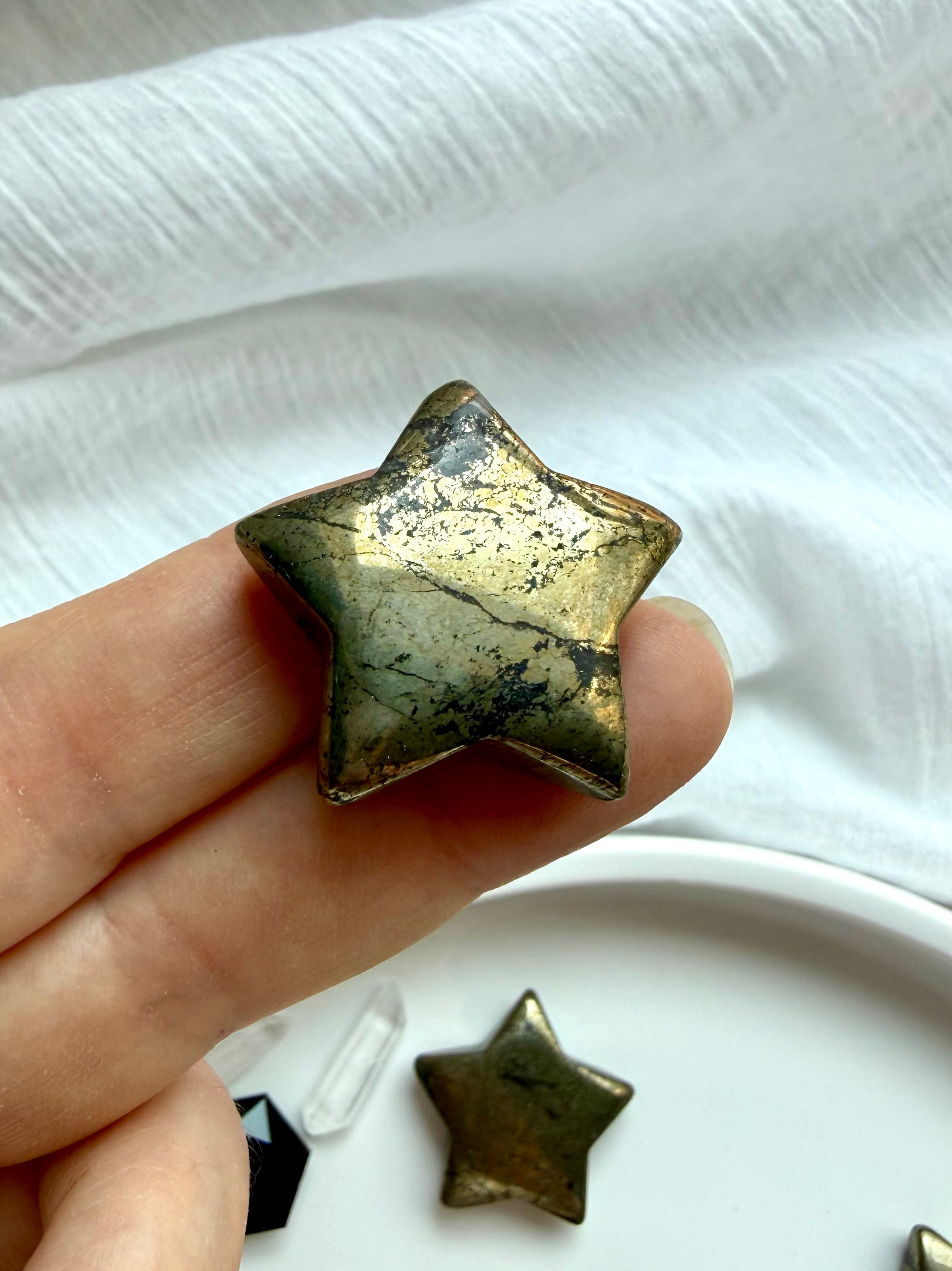 Close-up of polished Pyrite star carving with sparkling metallic texture and natural golden-bronze luster