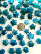 Blue Apatite mini crystal stars shown with a dime for scale — star-shaped teal crystals for spiritual clarity & self-expression.