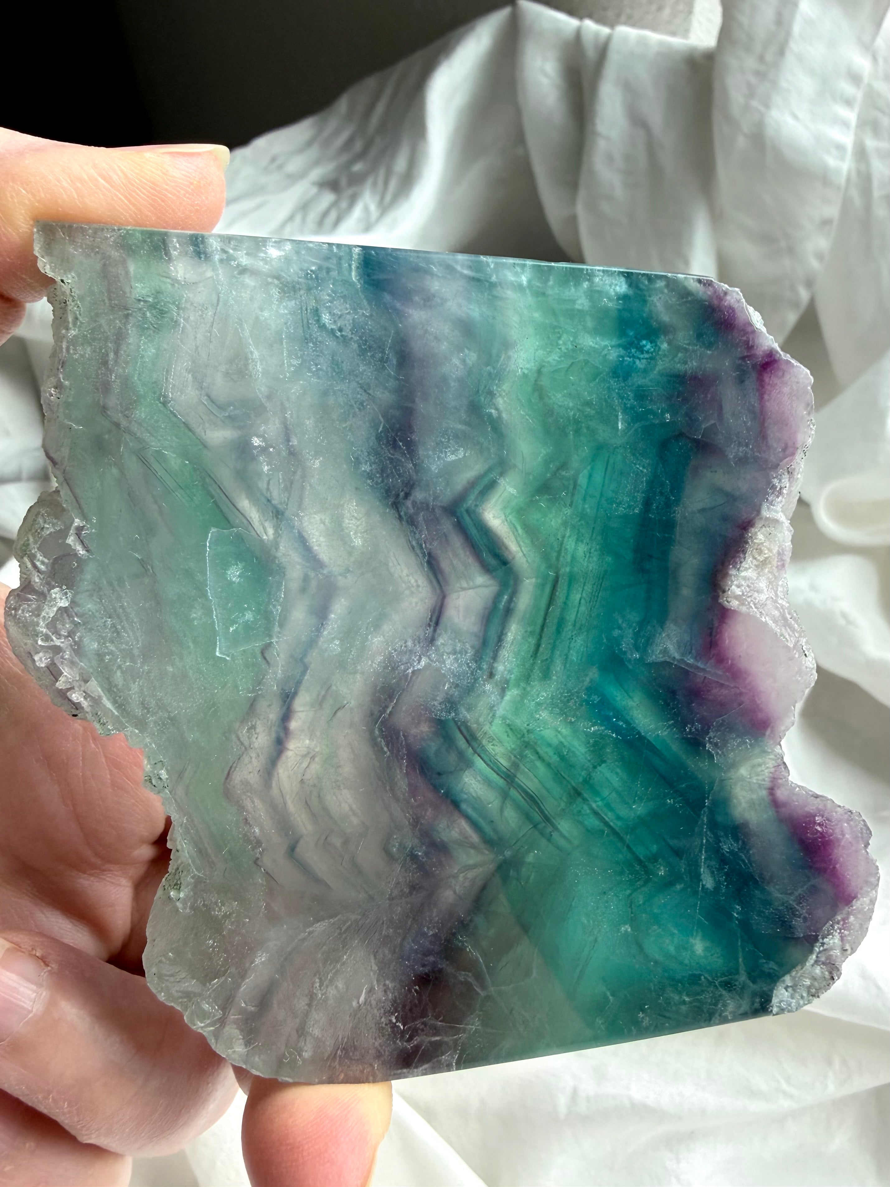 Polished fluorite slab photographed in natural light highlighting teal and purple crystal banding