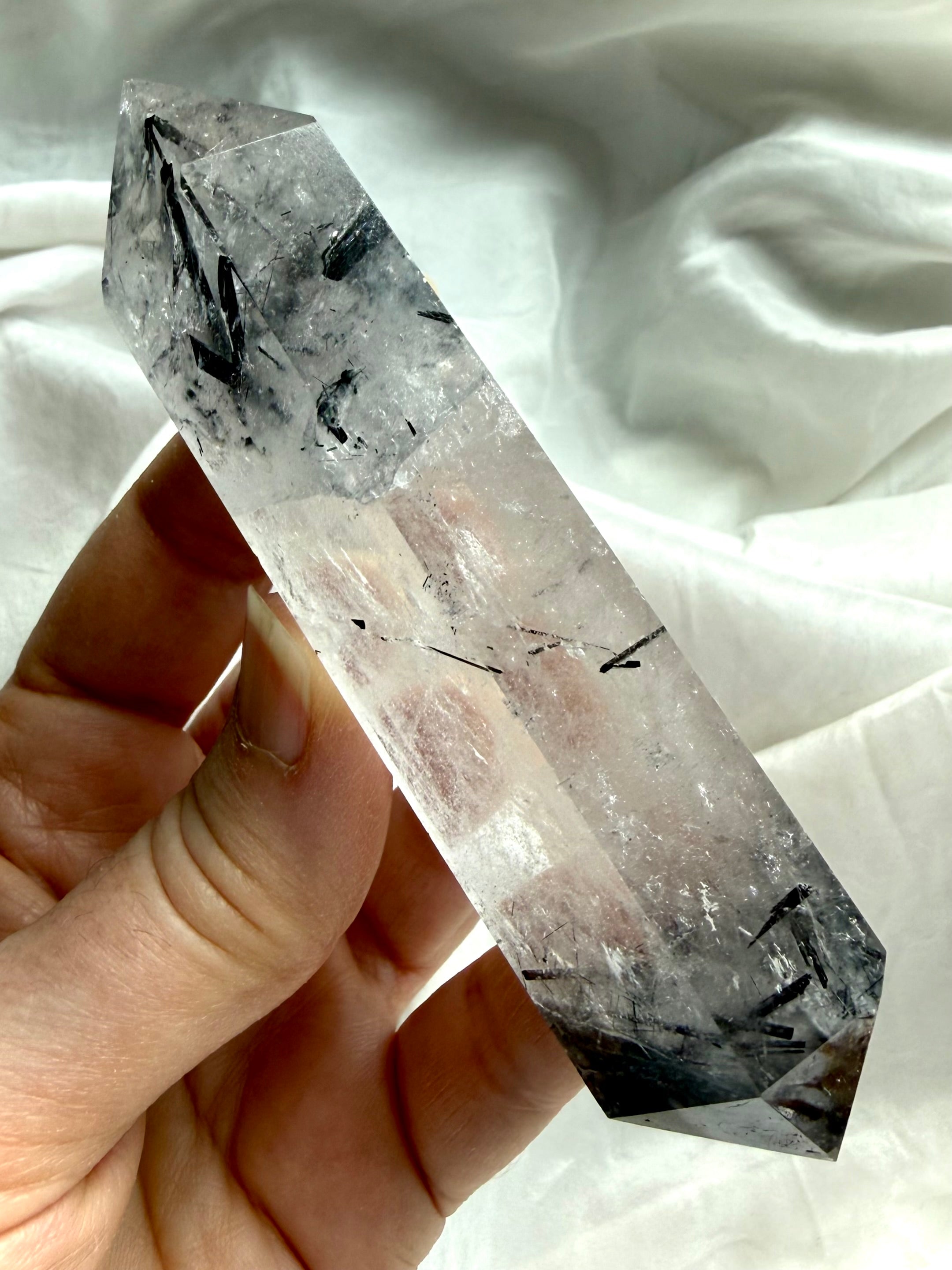 black tourmaline in quartz DT crystal held in hand for size reference