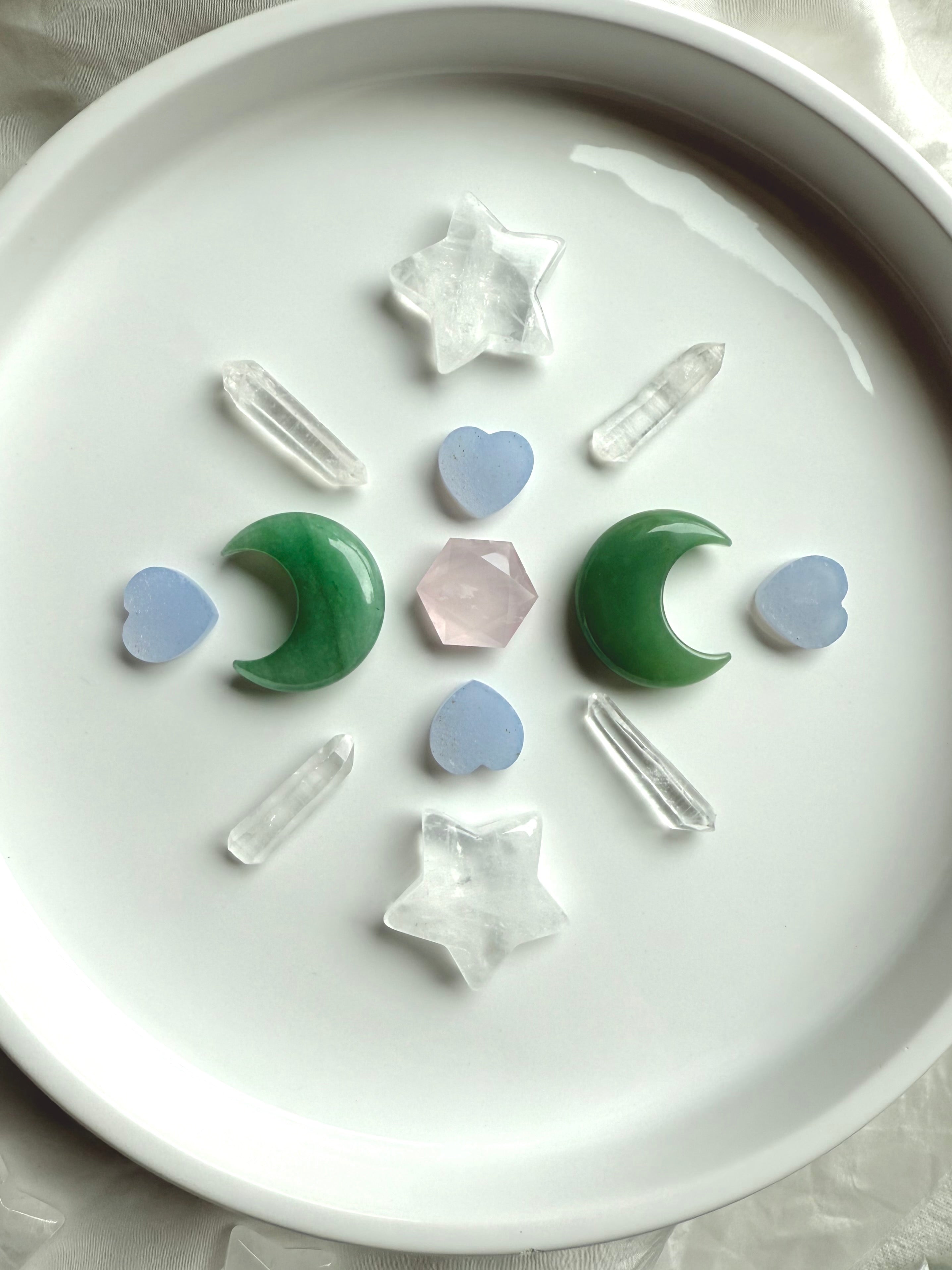 Crystal grid with Clear Quartz stars, Green Aventurine moons, Blue Chalcedony hearts, quartz points, and Rose Quartz hexagon in center, sacred geometry layout for healing