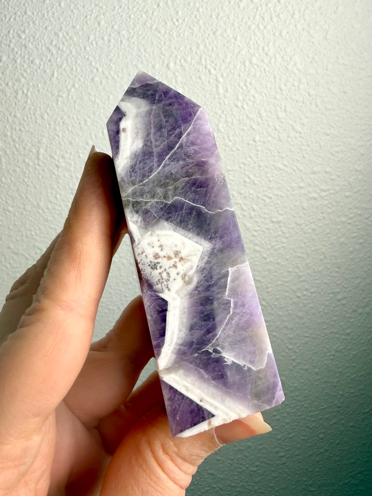 Dream Amethyst tower crystal with striking purple and white Chevron Amethyst banding, polished six-sided point and natural quartz patterns