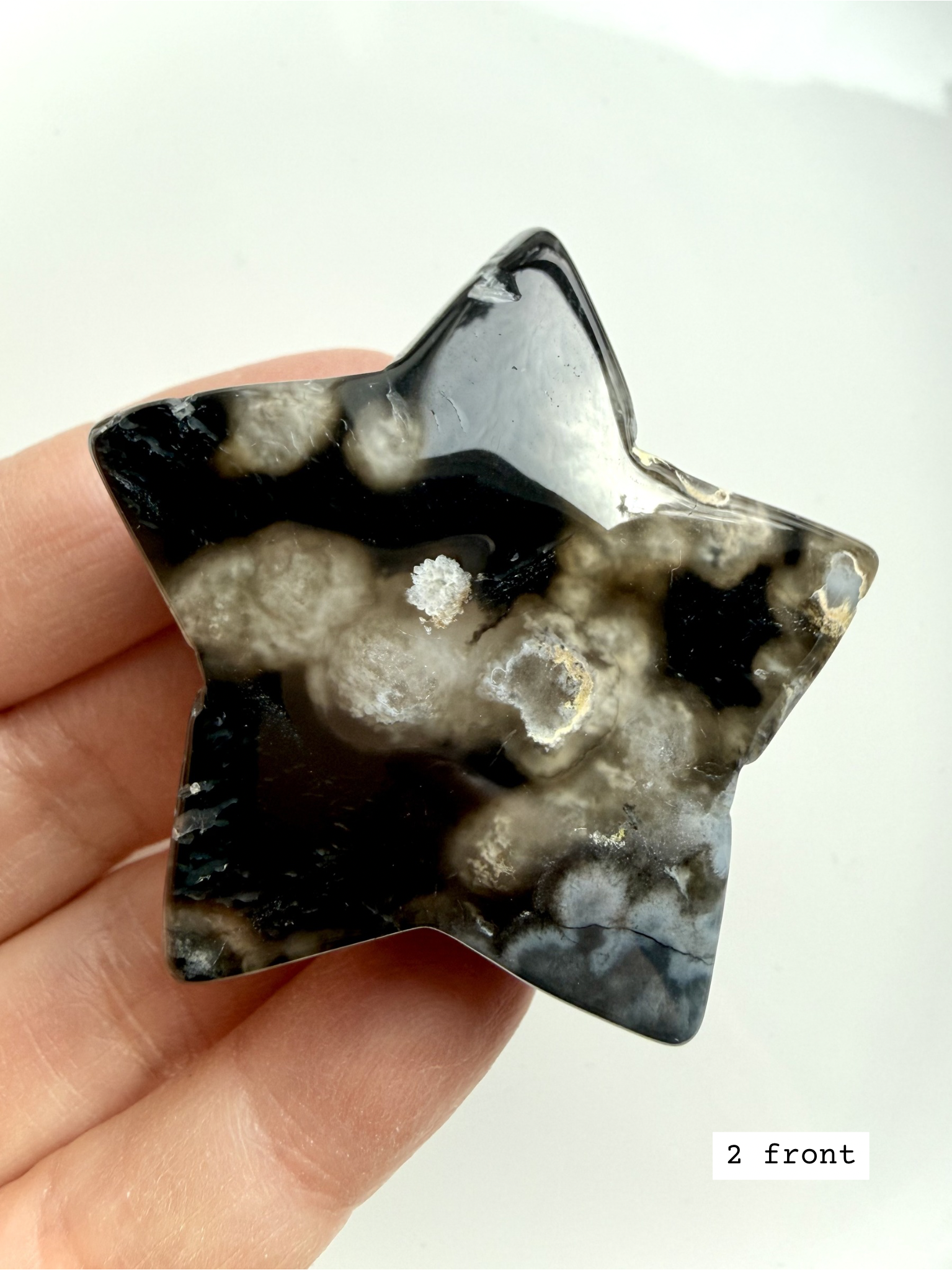 black flower agate star carving #2 front showing white floral plume patterns and polished finish