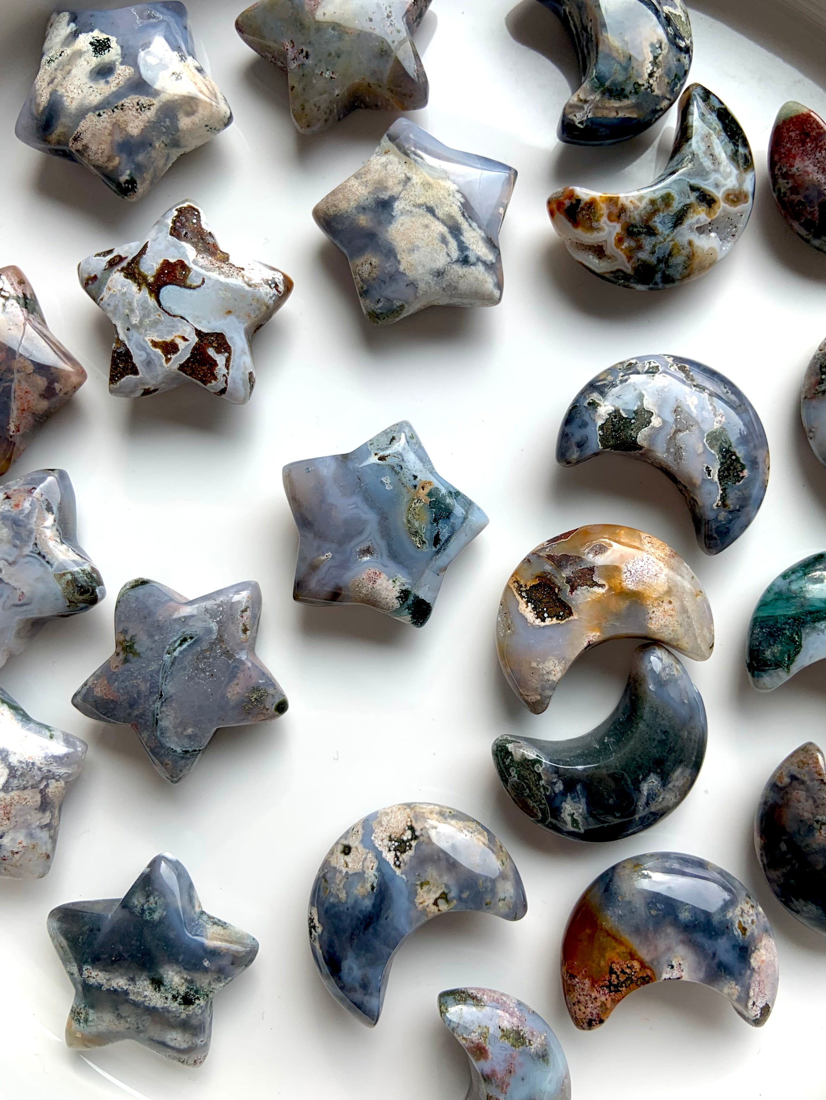 Closeup of Cosmic Ocean Jasper moons and stars carvings for crystal healing