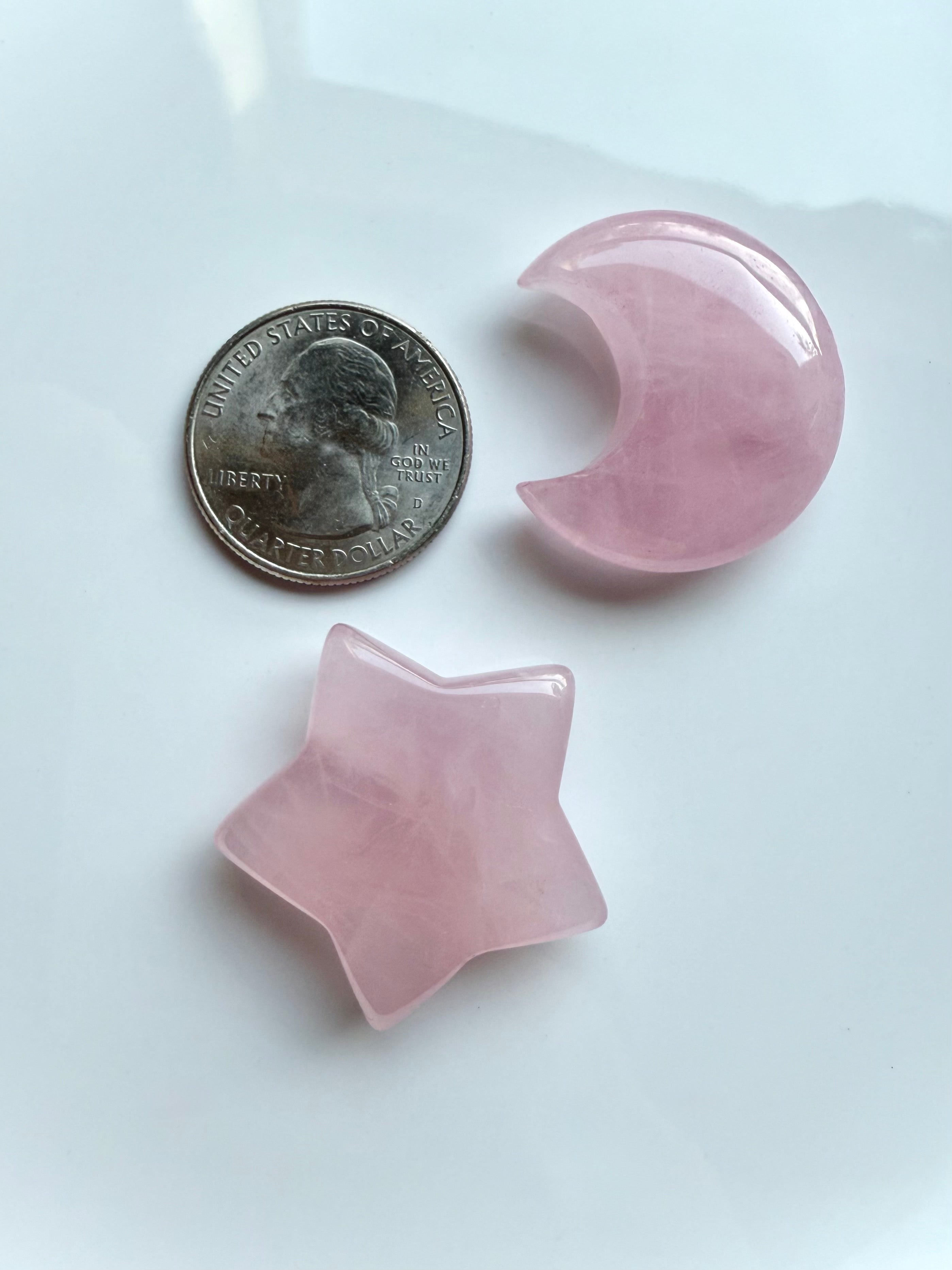 Closeup of rose quartz moon and star crystals shown with a US quarter for size reference
