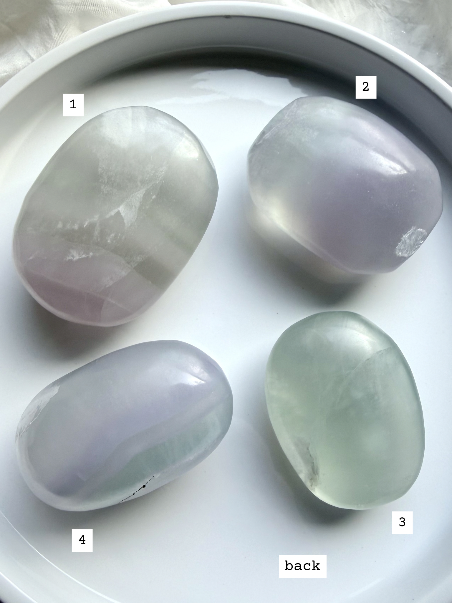 polished yttrium fluorite palm stones back view, options 1-4 showing variations in natural banding and soft translucent glow