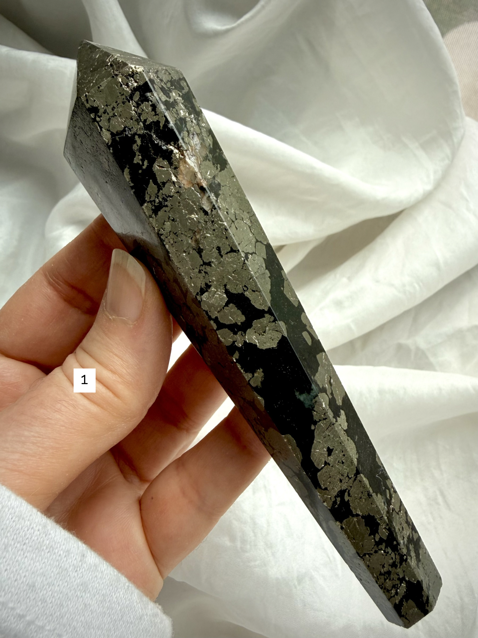 pyrite wand in black matrix held in hand polished crystal point option 1